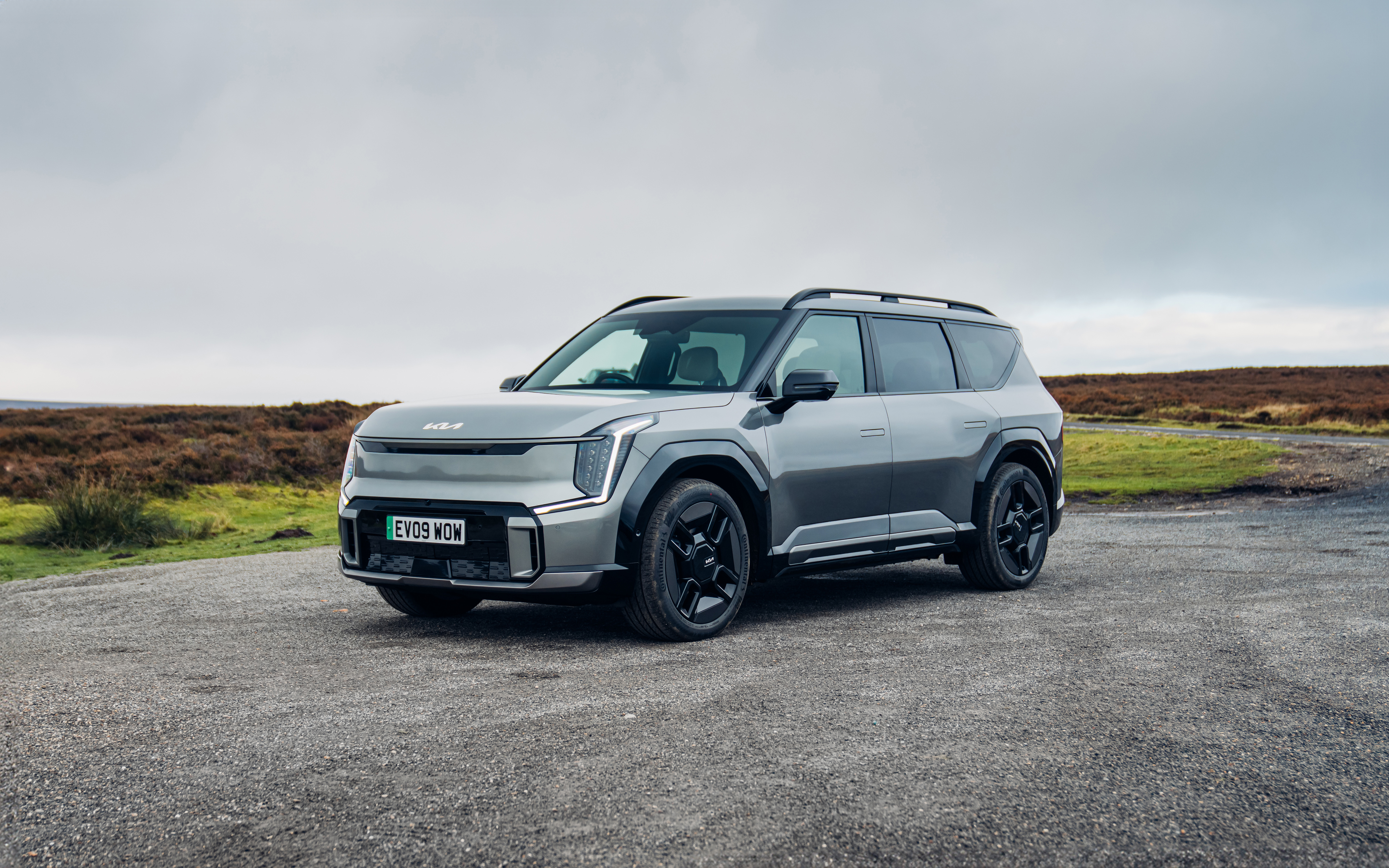 Ein grauer Kia EV9 steht an einem Feld