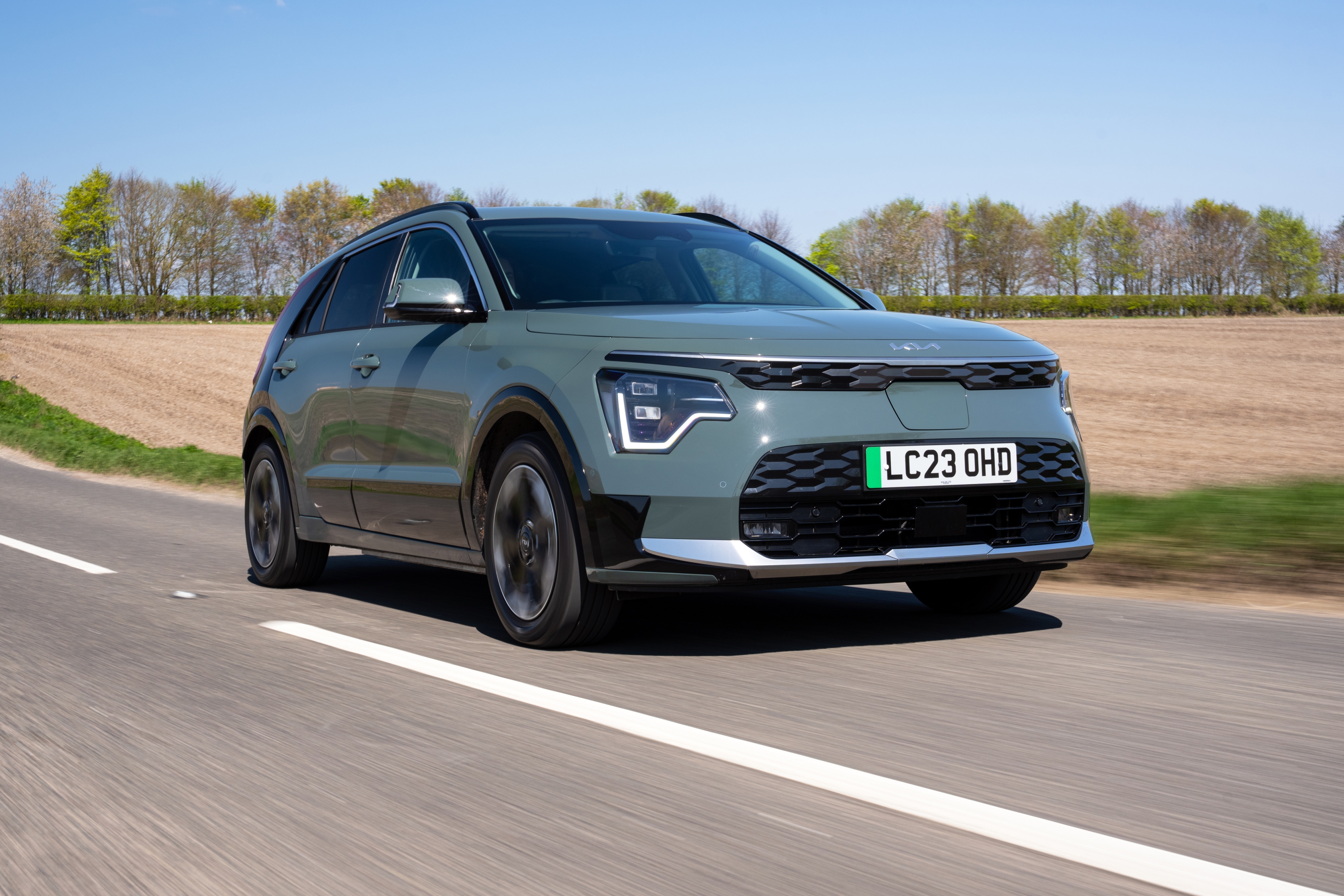 Ein grauer Kia e-Niro fährt auf einer Landtraße