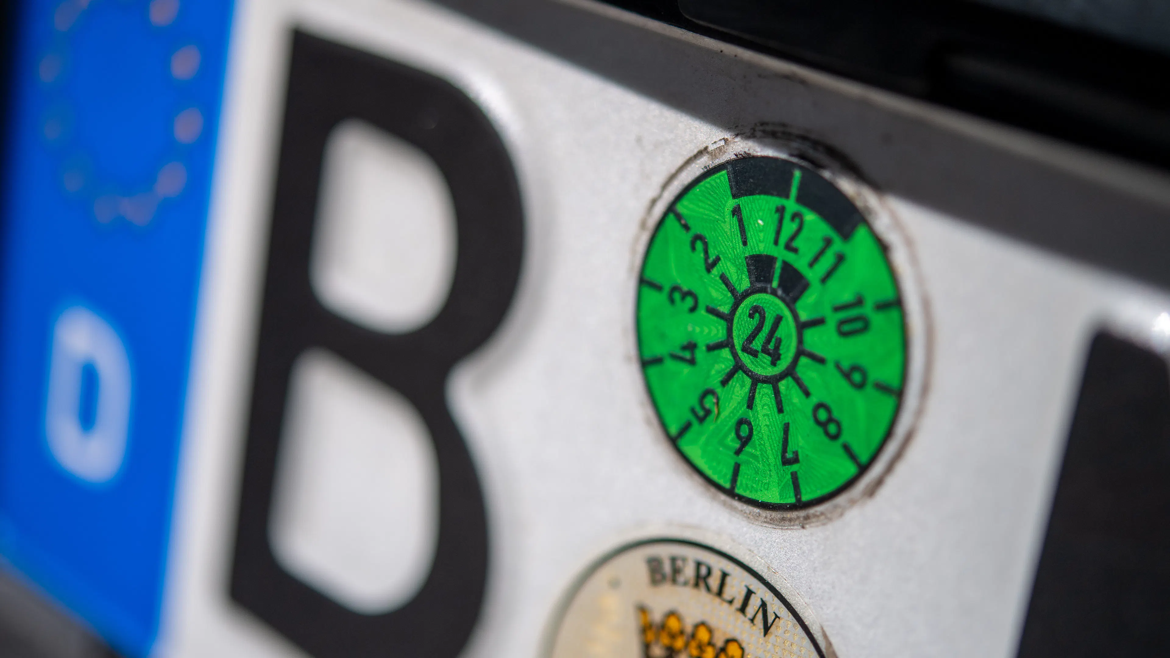 Großaufnahme einer HU-Plakette auf einem Nummernschild.