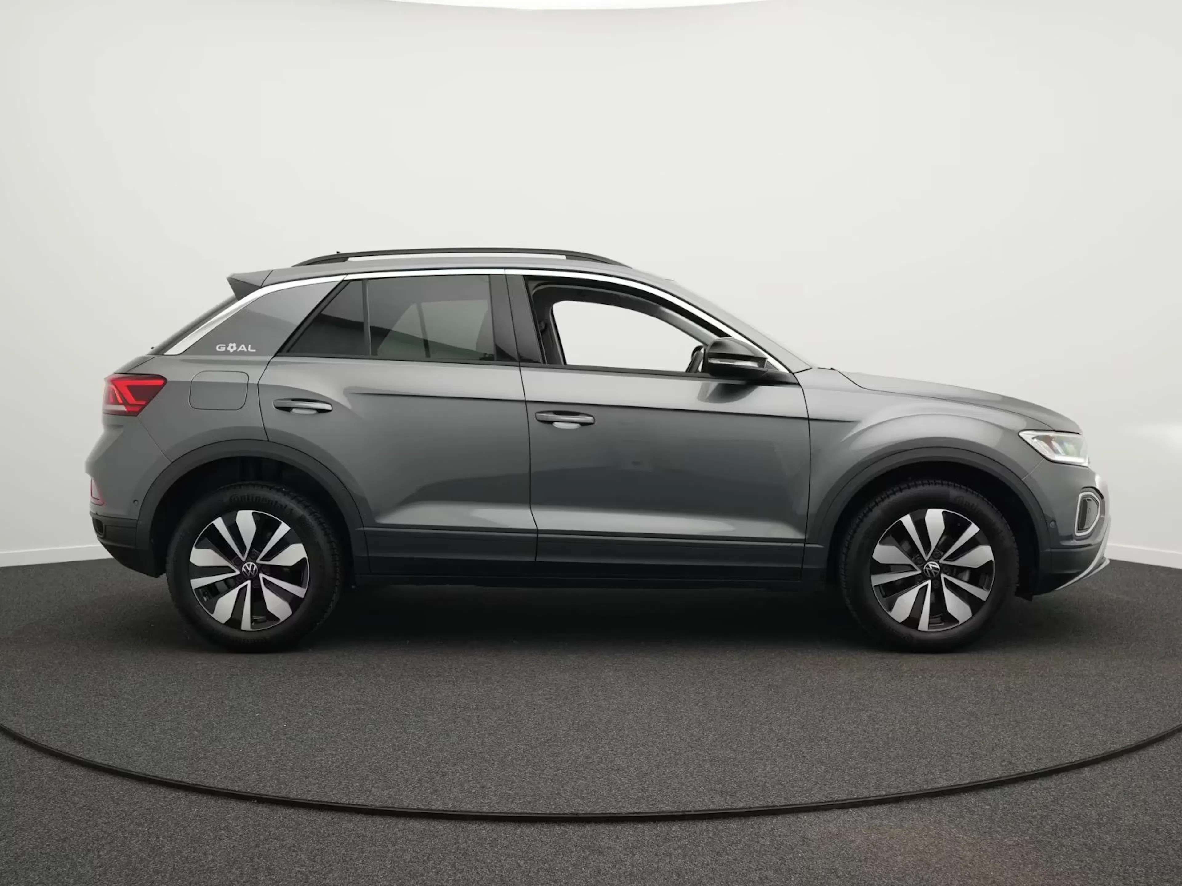 Ein grauer VW T-Roc steht auf einer Verkaufsfläche.