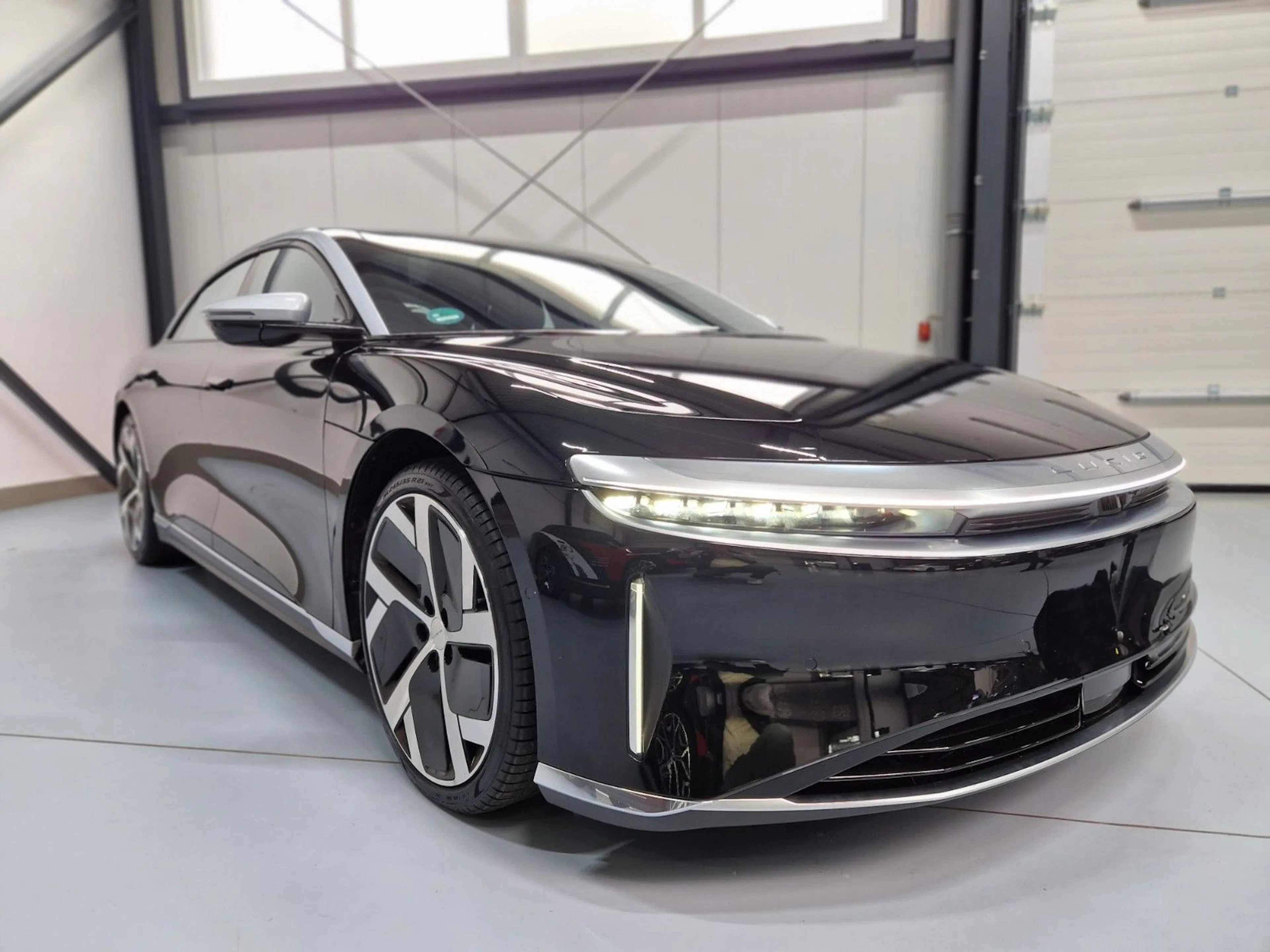 Ein schwarzer Lucid Air in einer Händlerhalle.