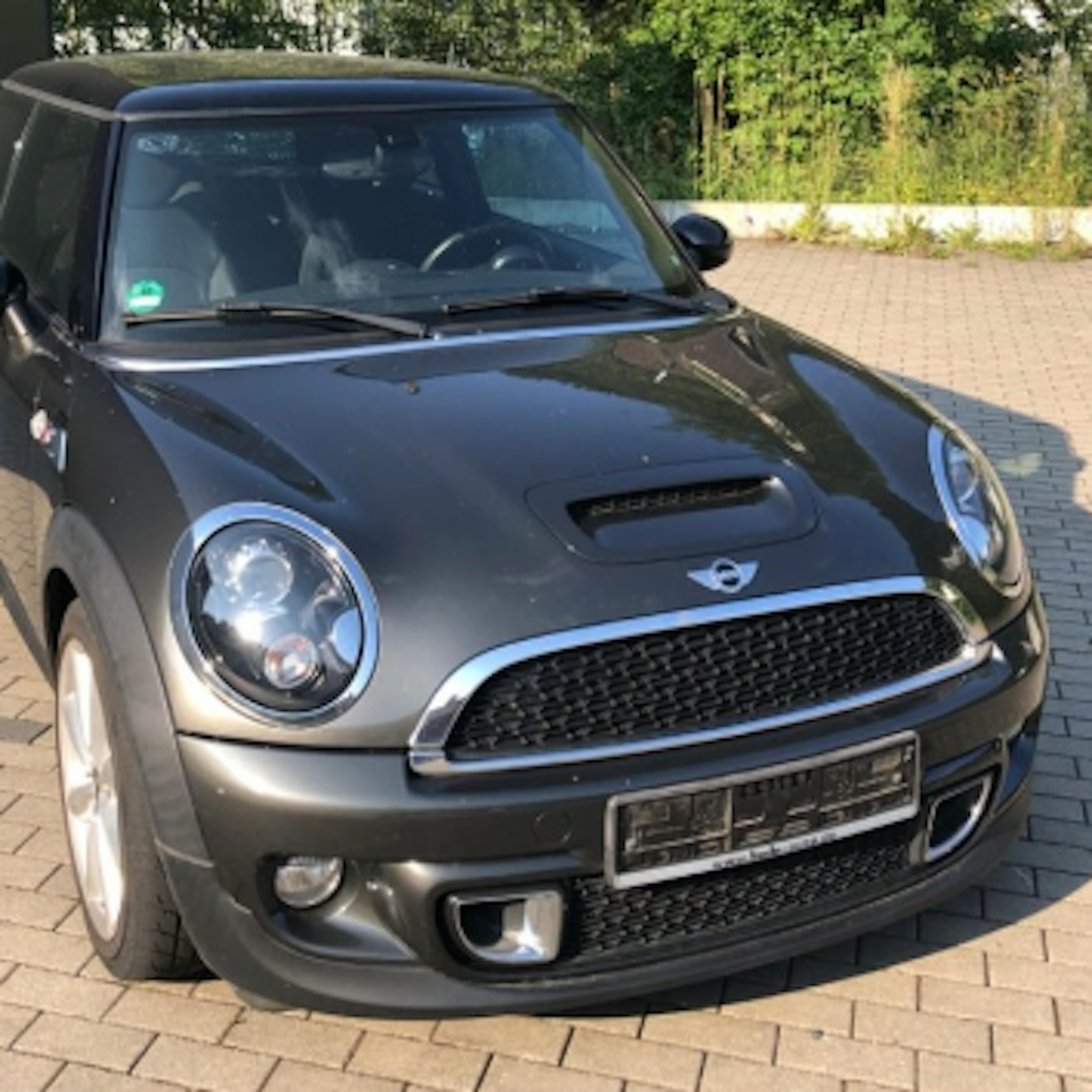 A gray Mini Cooper in a driveway
