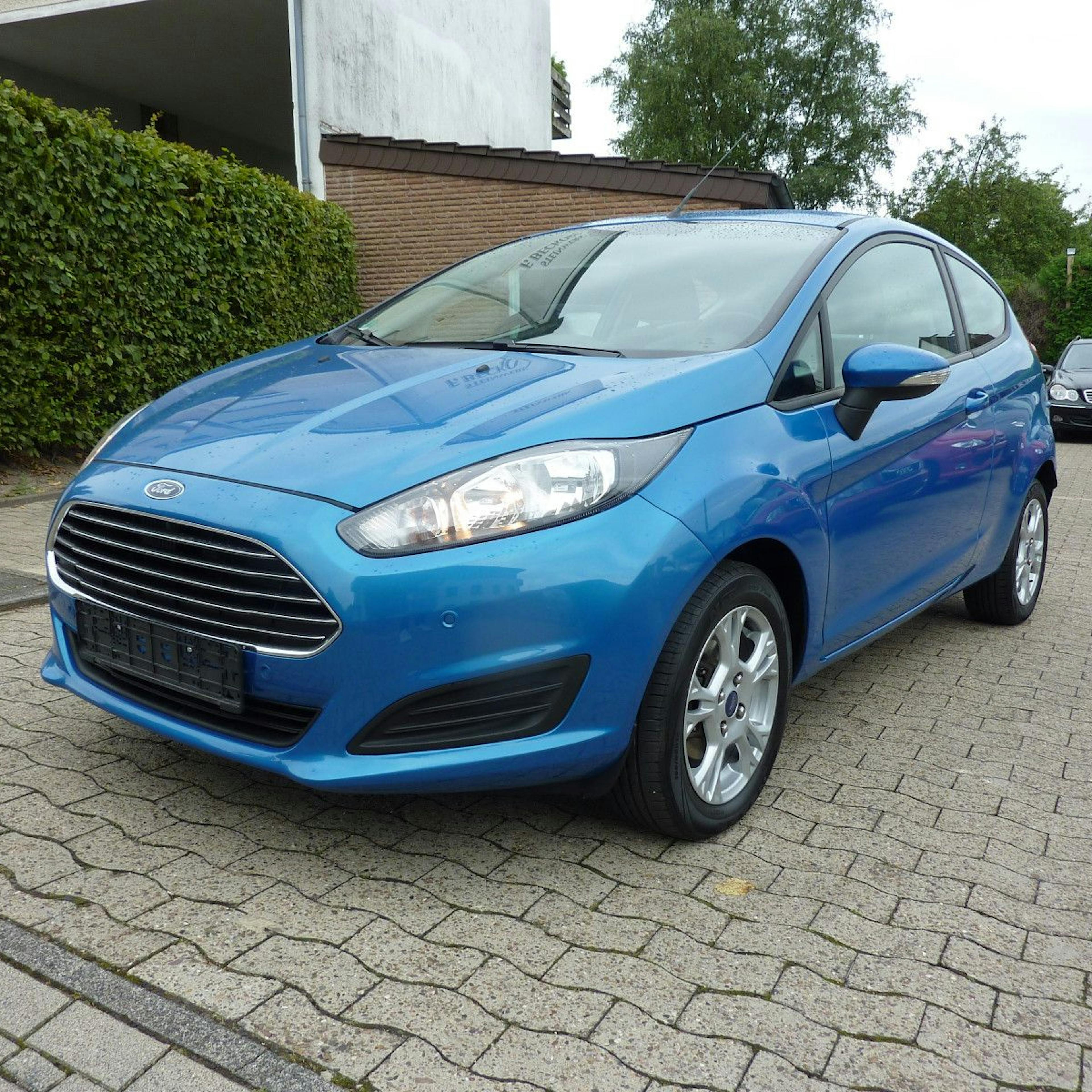 A blue Ford Fiesta in a driveway