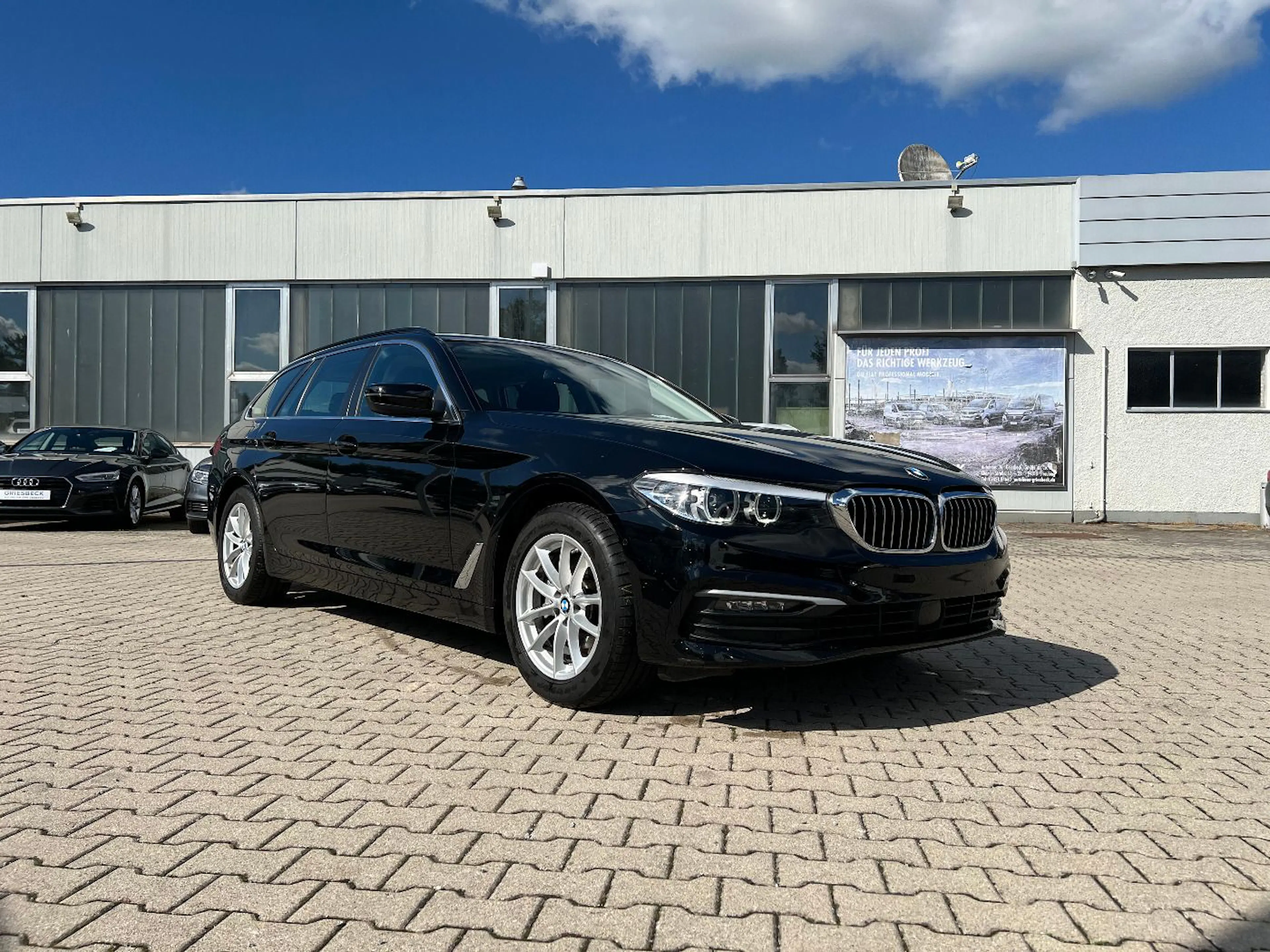 Ein BMW 5er touring steht auf einem Händlerhof