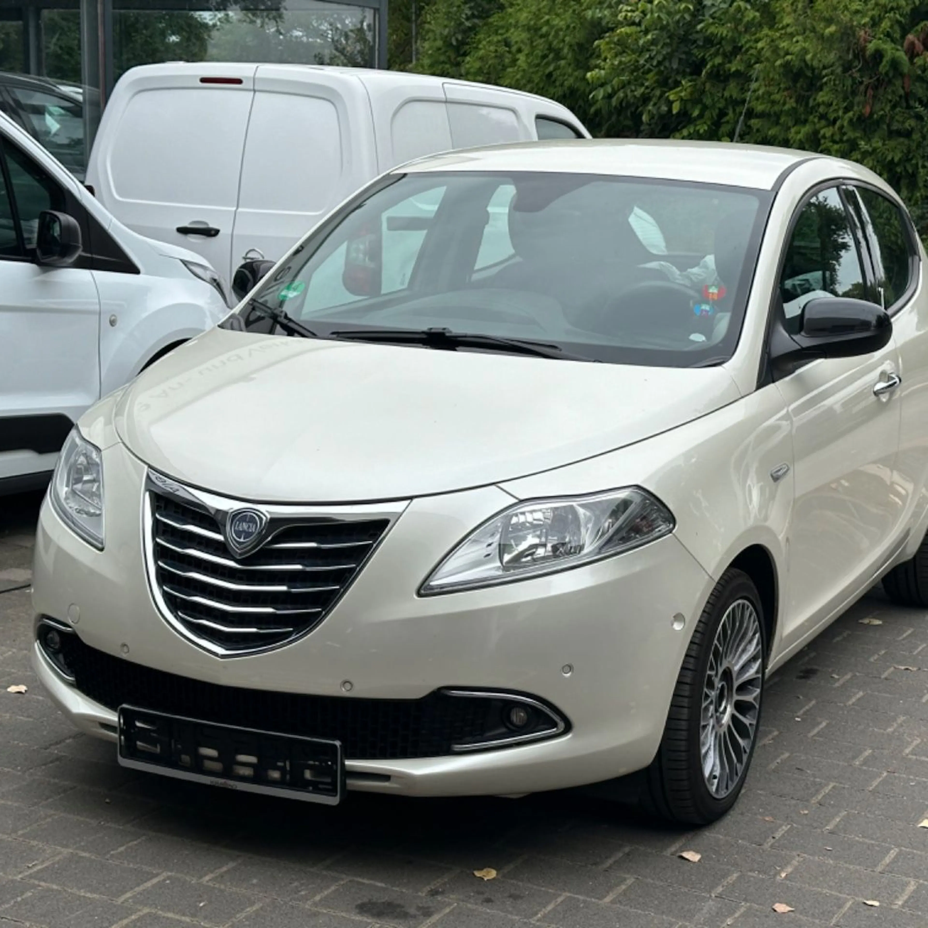 Ein cremefarbener Lancia Ypsilon, Frontansicht.
