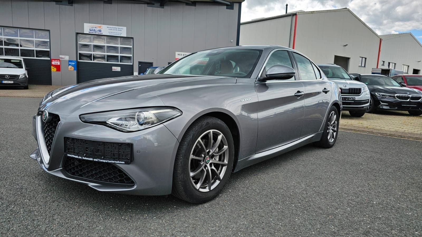 Ein silberner Alfa Romeo Giulia, seitliche Frontansicht.