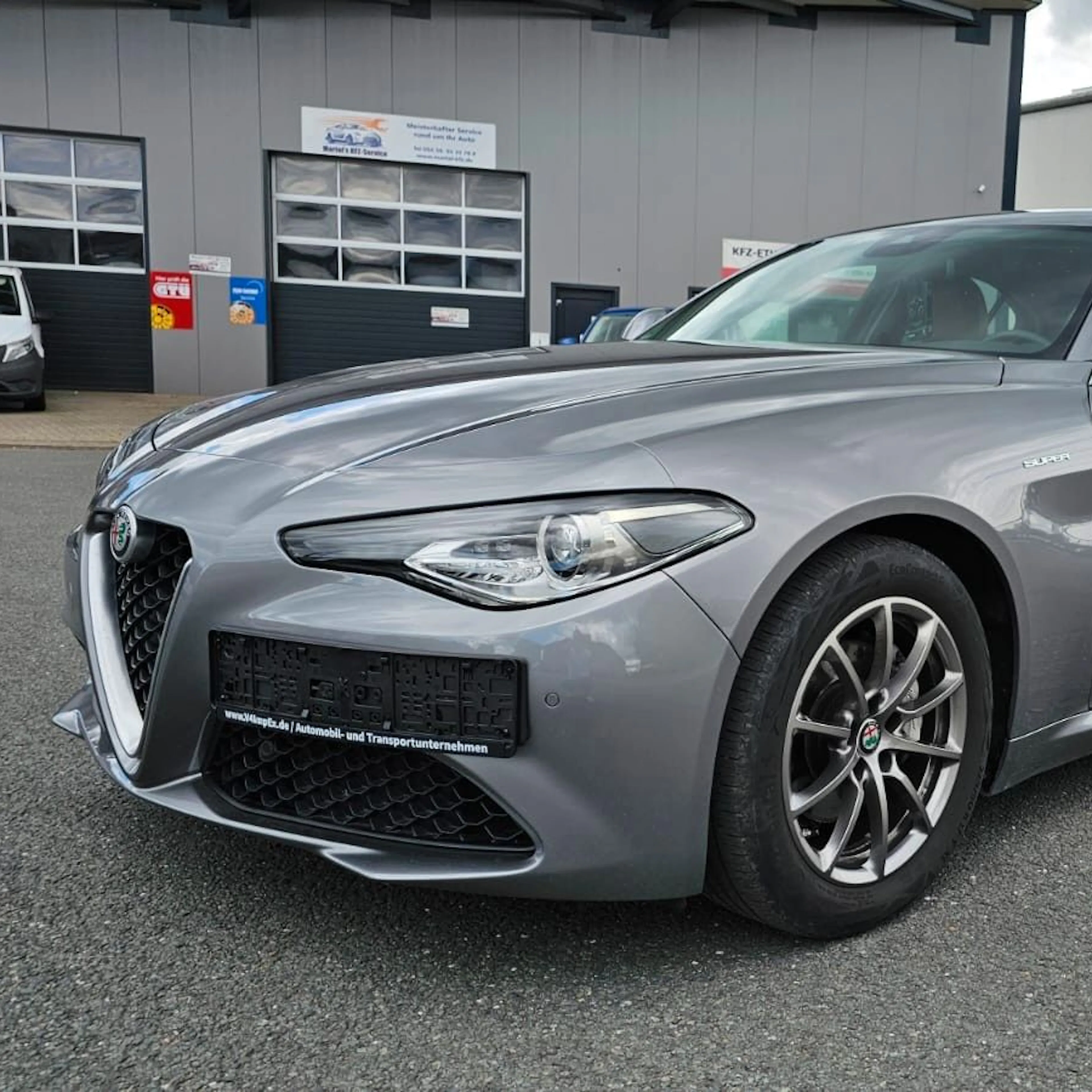 Ein silberner Alfa Romeo Giulia, seitliche Frontansicht.