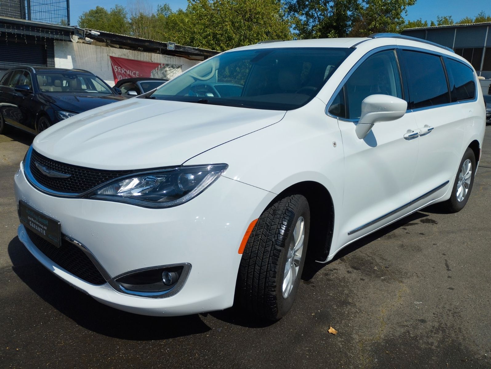 Ein schwarzer Chrysler Pacifica parkt vor einer modernen Backsteinfassade.
