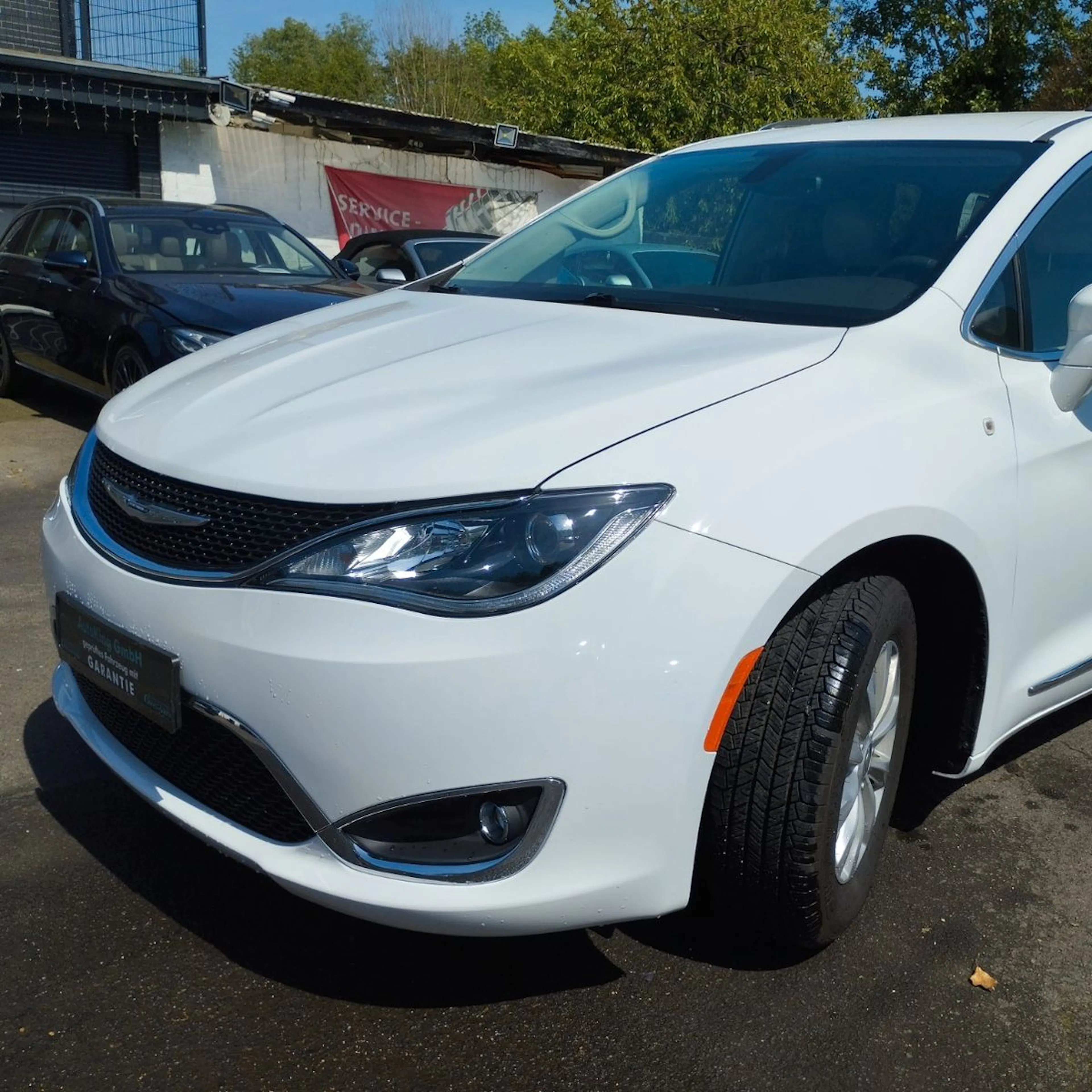 Ein schwarzer Chrysler Pacifica parkt vor einer modernen Backsteinfassade.