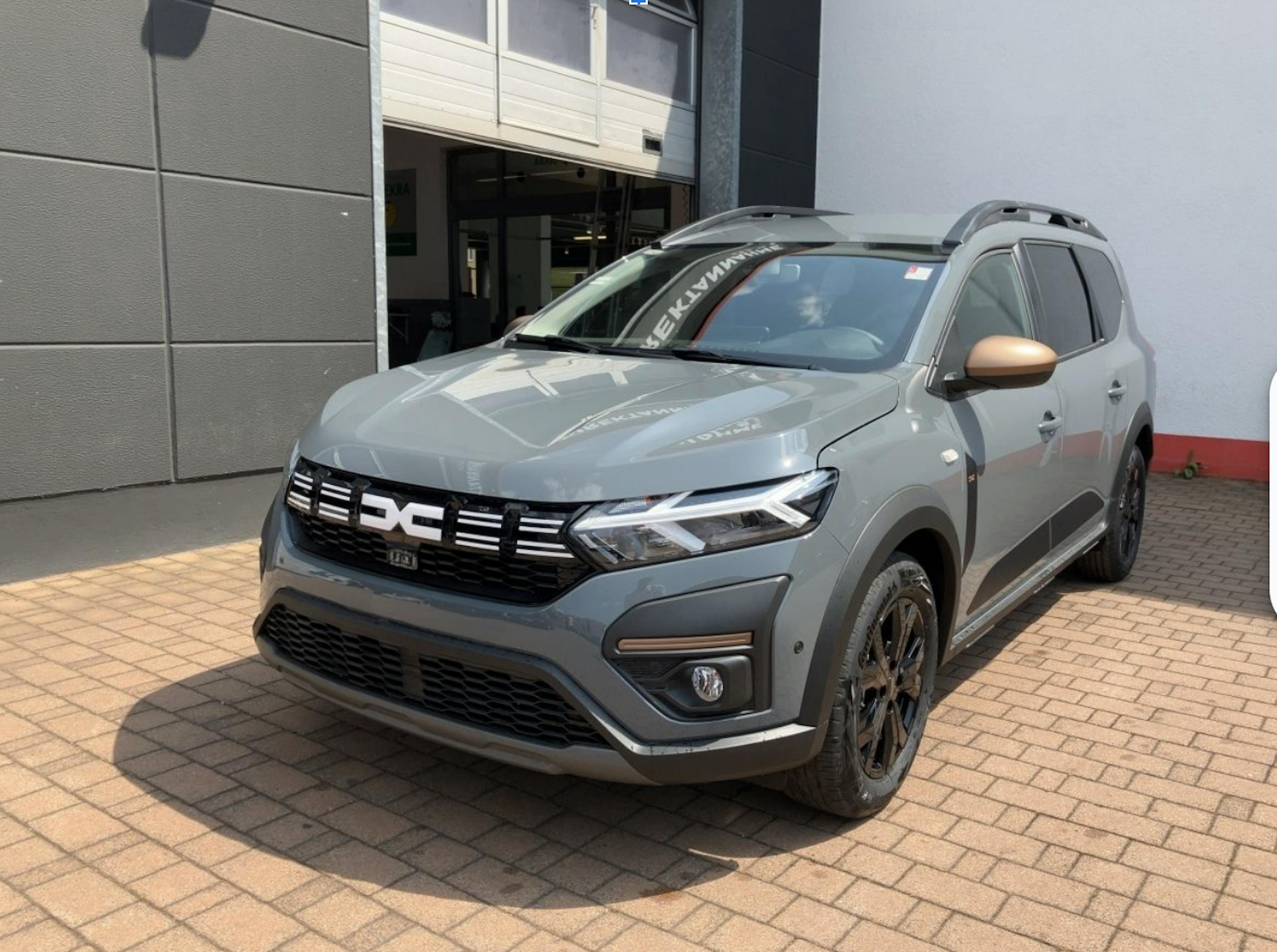 Ein grauer Dacia Jogger auf dem Hof einer Autowerkstatt.
