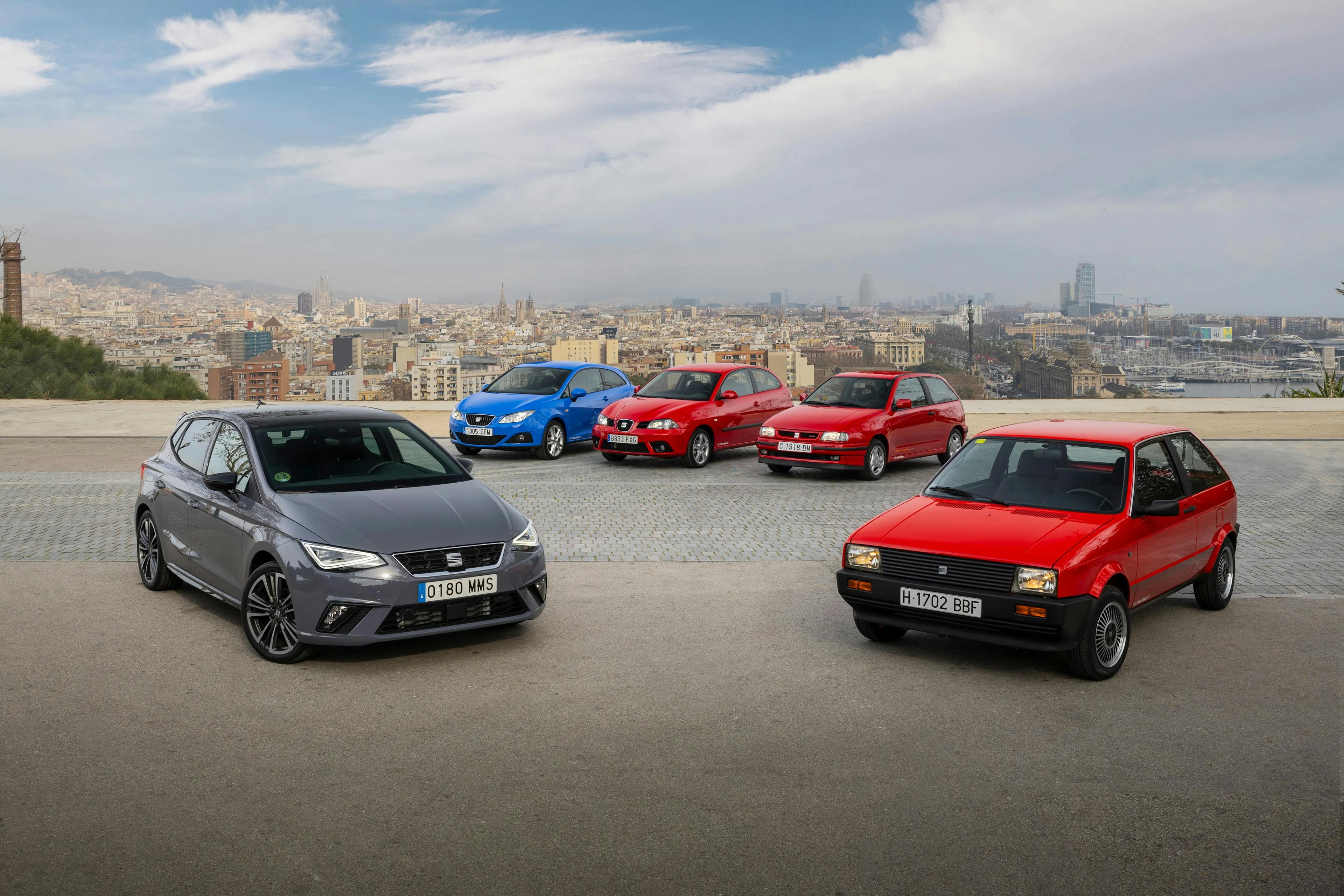 Mehrere Seat Ibiza verschiedener Generationen stehen vor einer Stadtlandschaft mit Blick auf die Skyline.