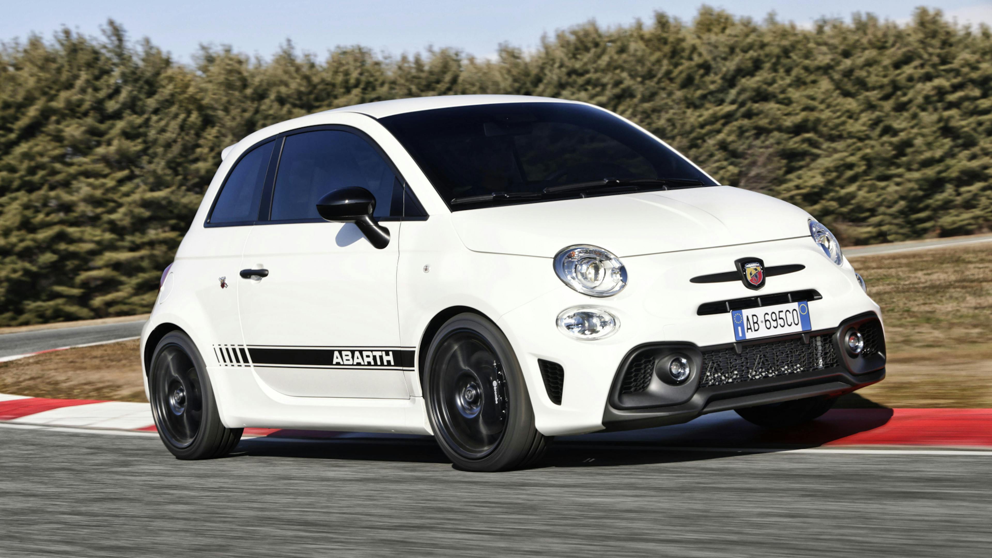 A white Abarth 695 is driving on a race track.