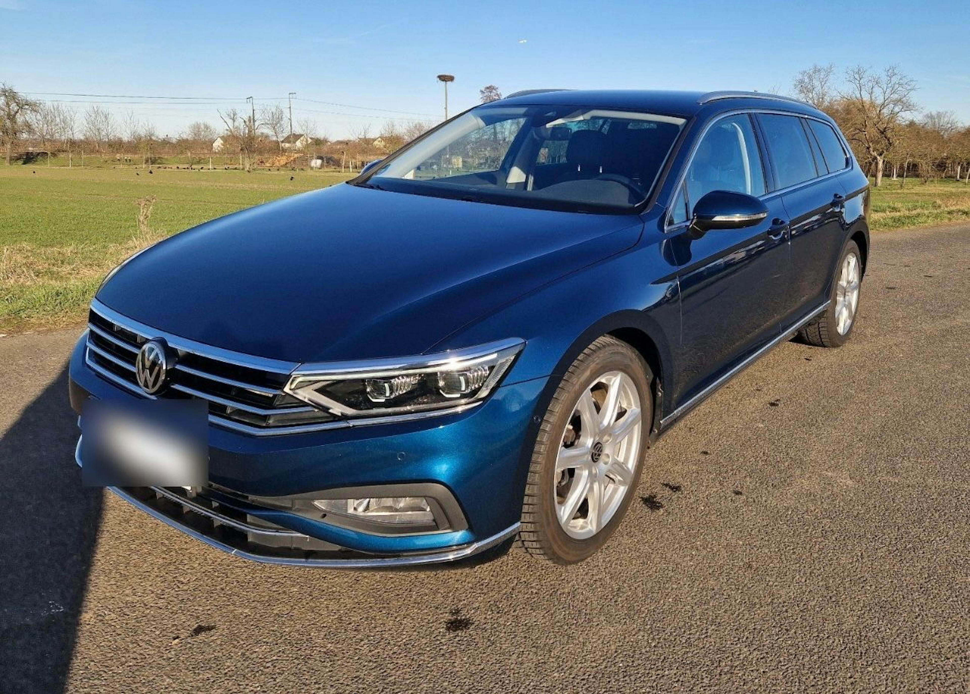 Ein blauer Passat parkt auf einer Asphaltstraße.