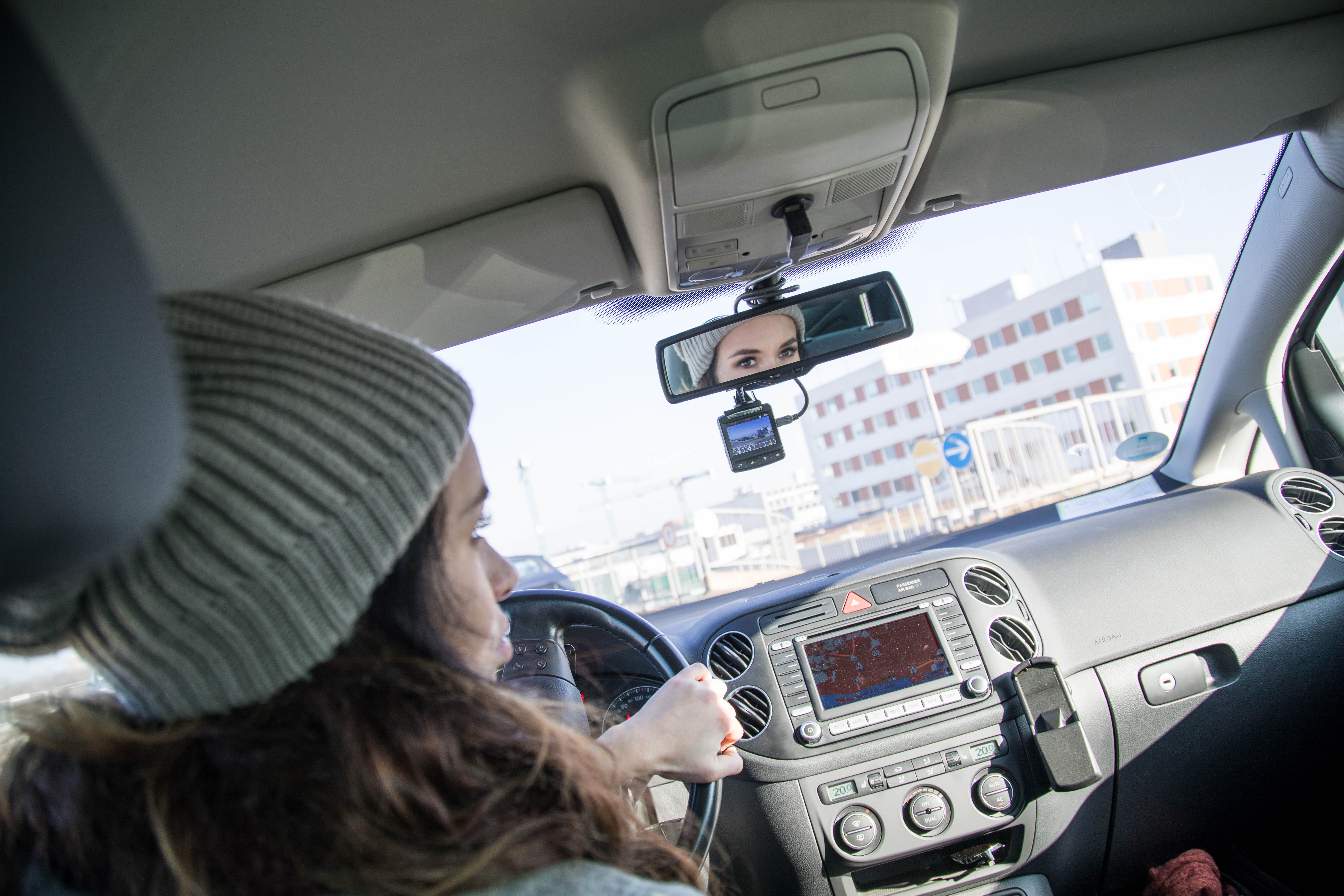 Eine Frau sitzt hinter dem Lenkrad eines Autos, das mit einer Dashcam ausgestattet ist.