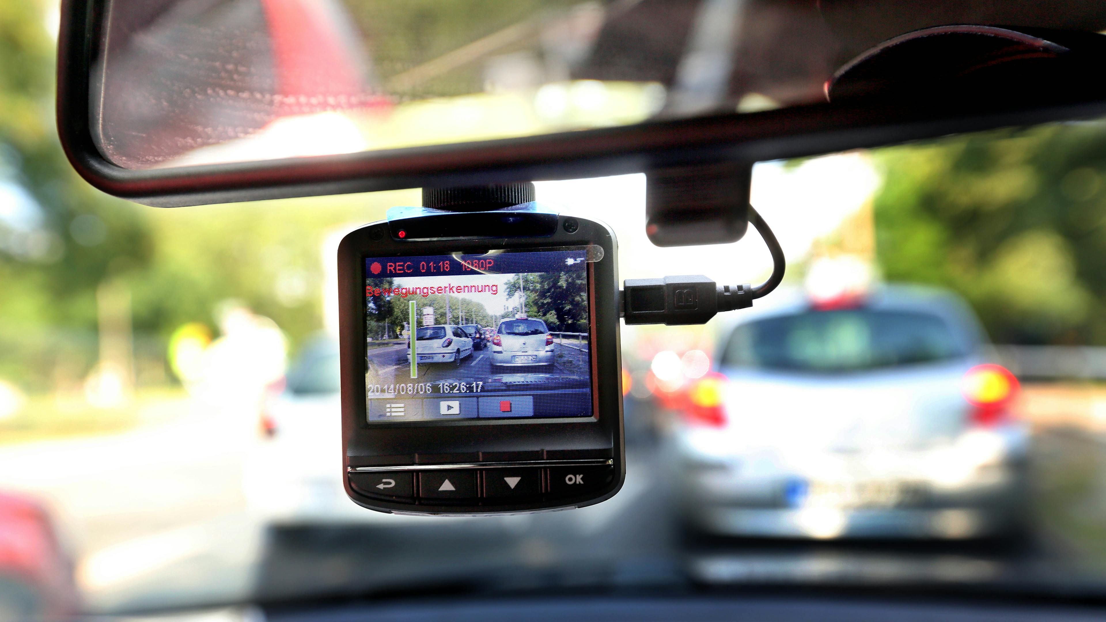 A dashcam, attached to the windshield, films road traffic in Berlin from a car.
