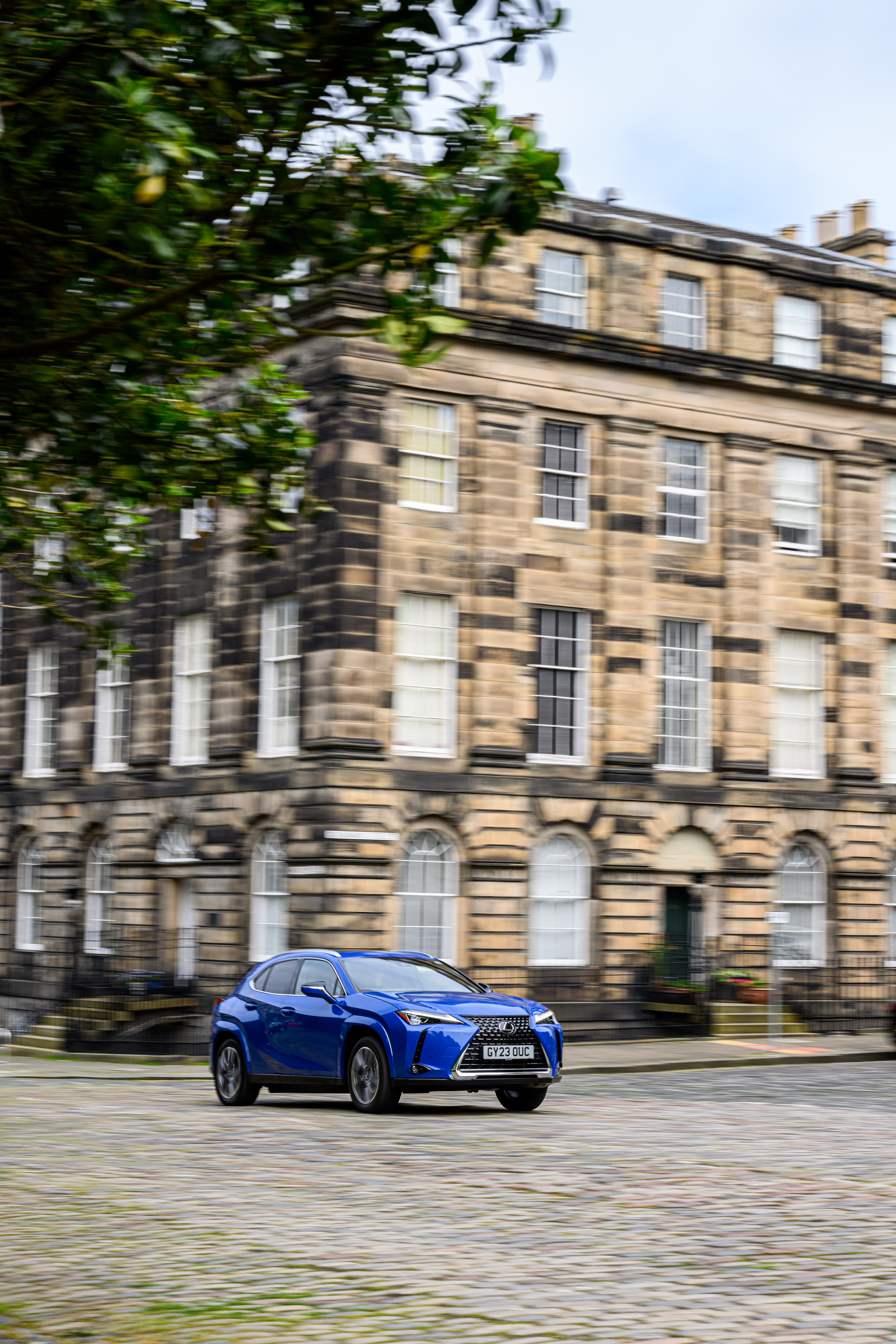 Lexus UX parkt vor einer Villa