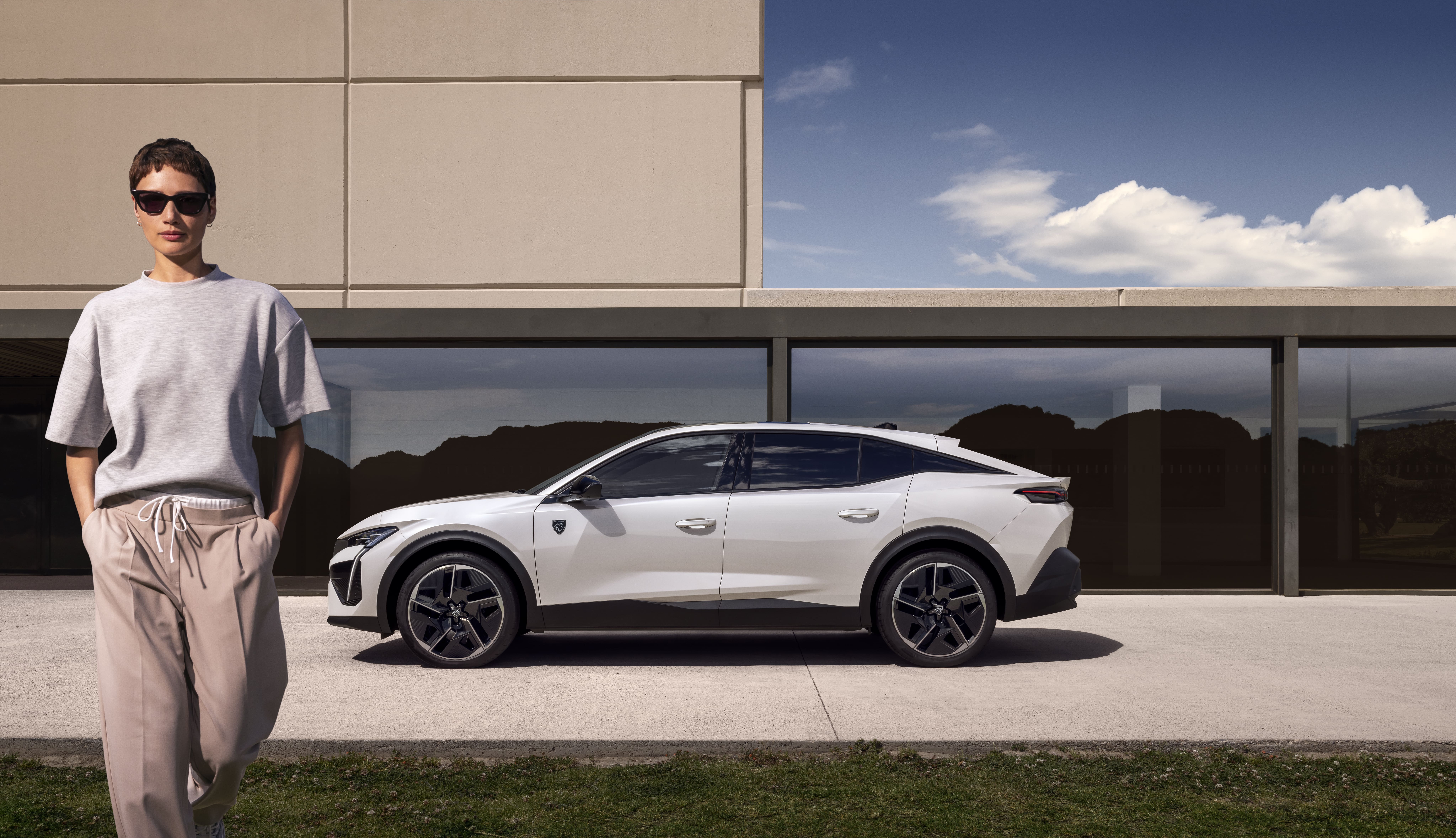 ein Peugeot e-408 parkt vor einem Haus