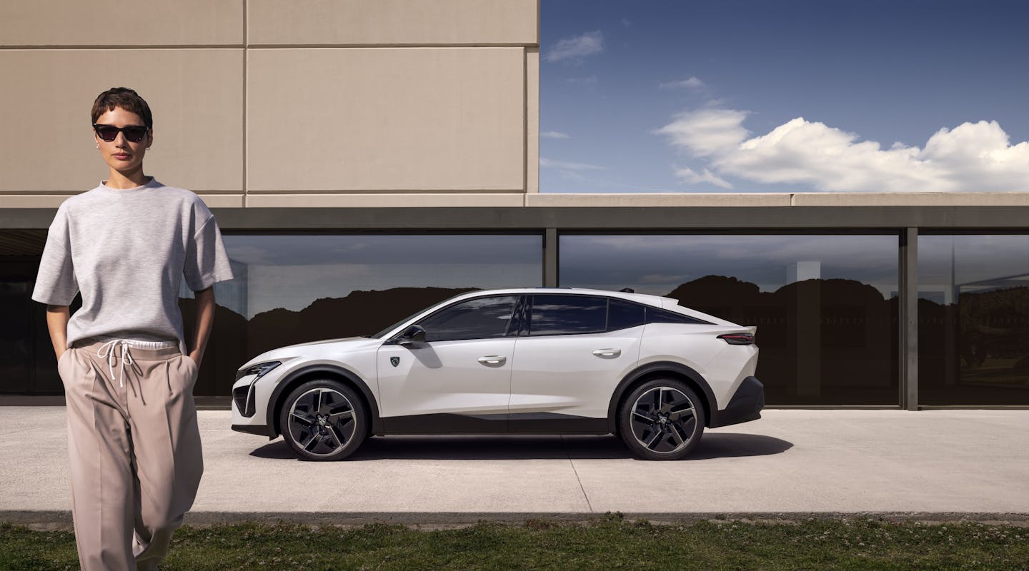 ein Peugeot e-408 parkt vor einem Haus