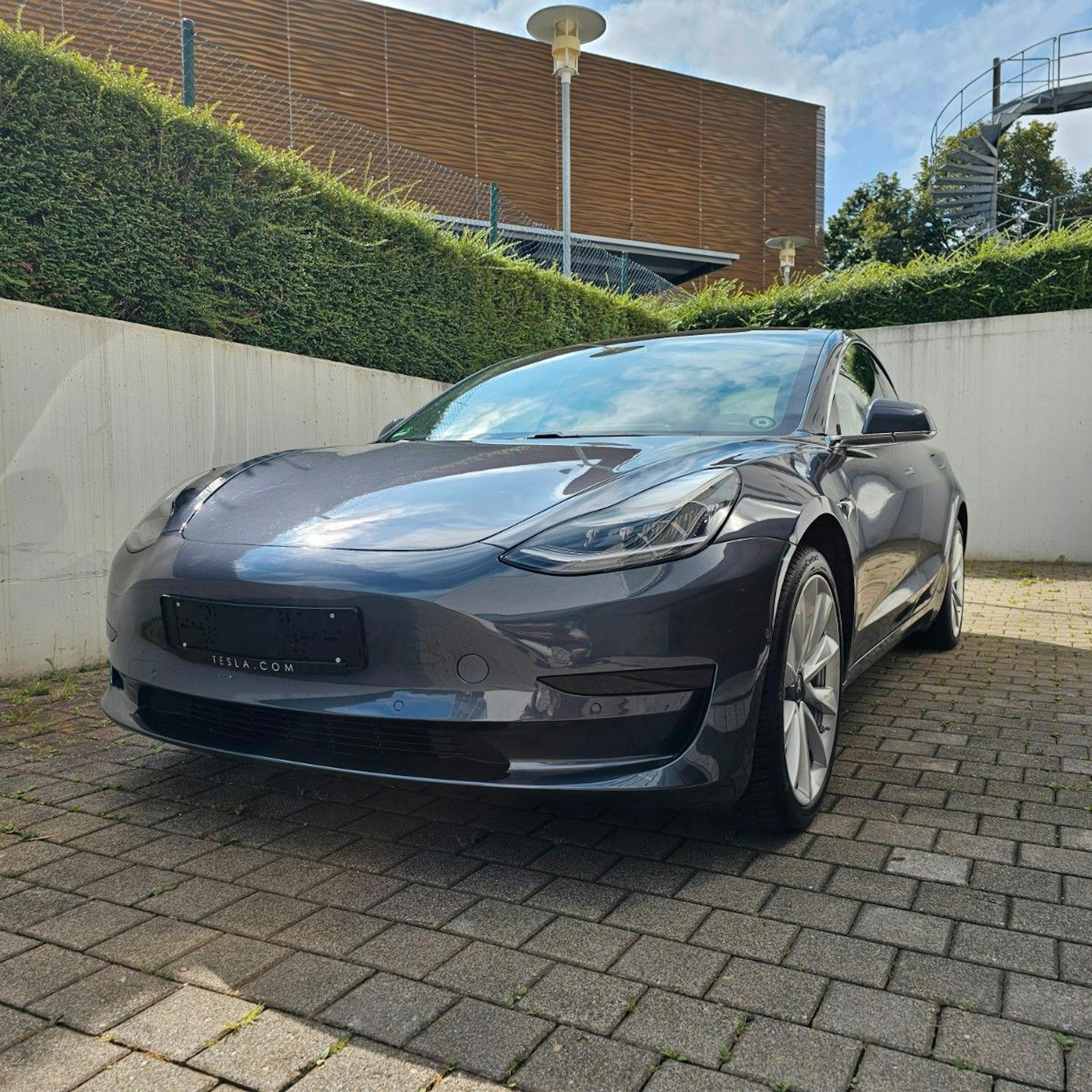 A gray Tesla Model 3, photographed from the front.