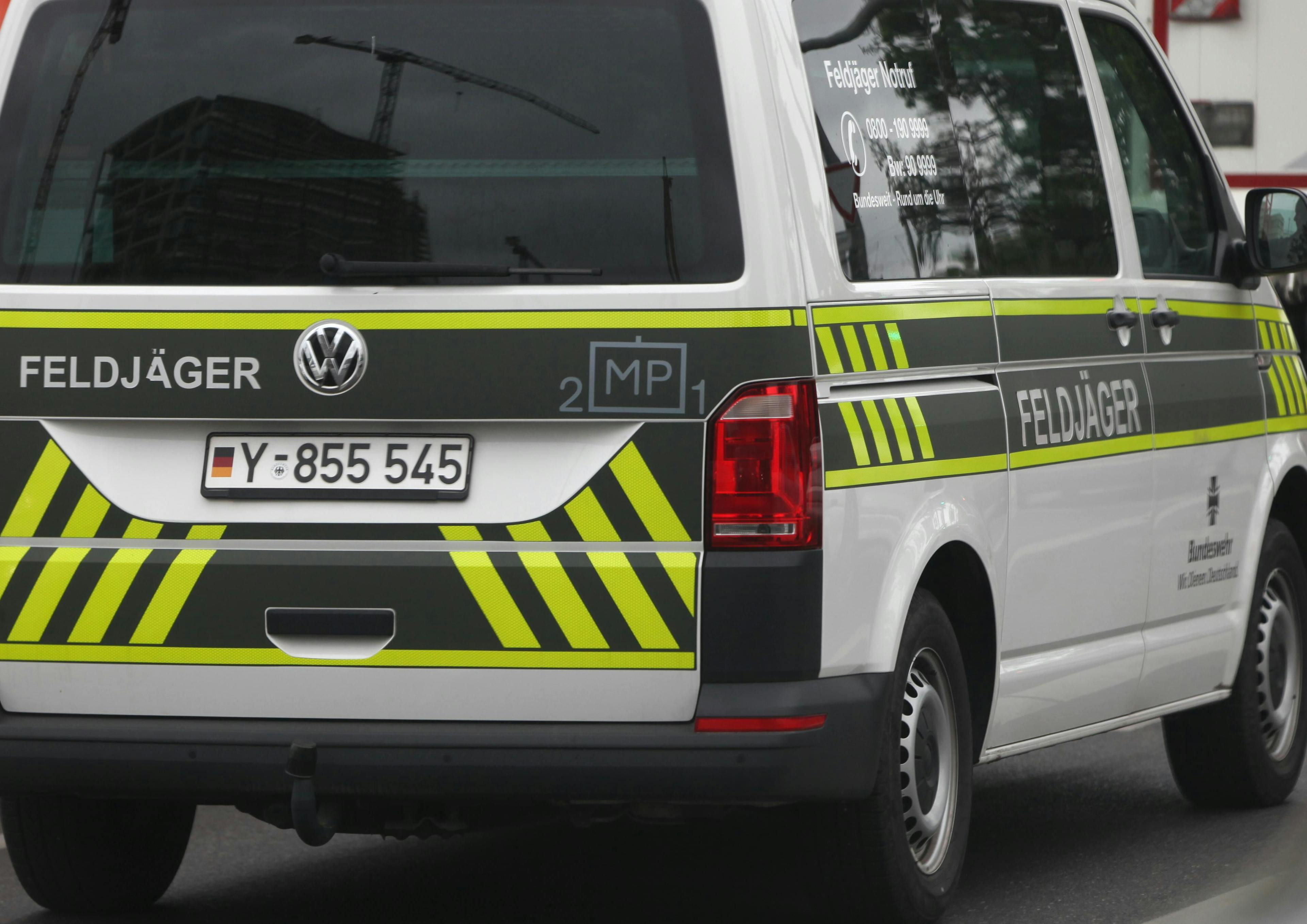 Ein Feldjägerfahrzeug der Bundeswehr mit dem Kennzeichen „Y-855 545“ fährt auf der Straße. Das Fahrzeug ist weiß mit grün-gelber Signalmarkierung und trägt die Aufschrift „Feldjäger“.