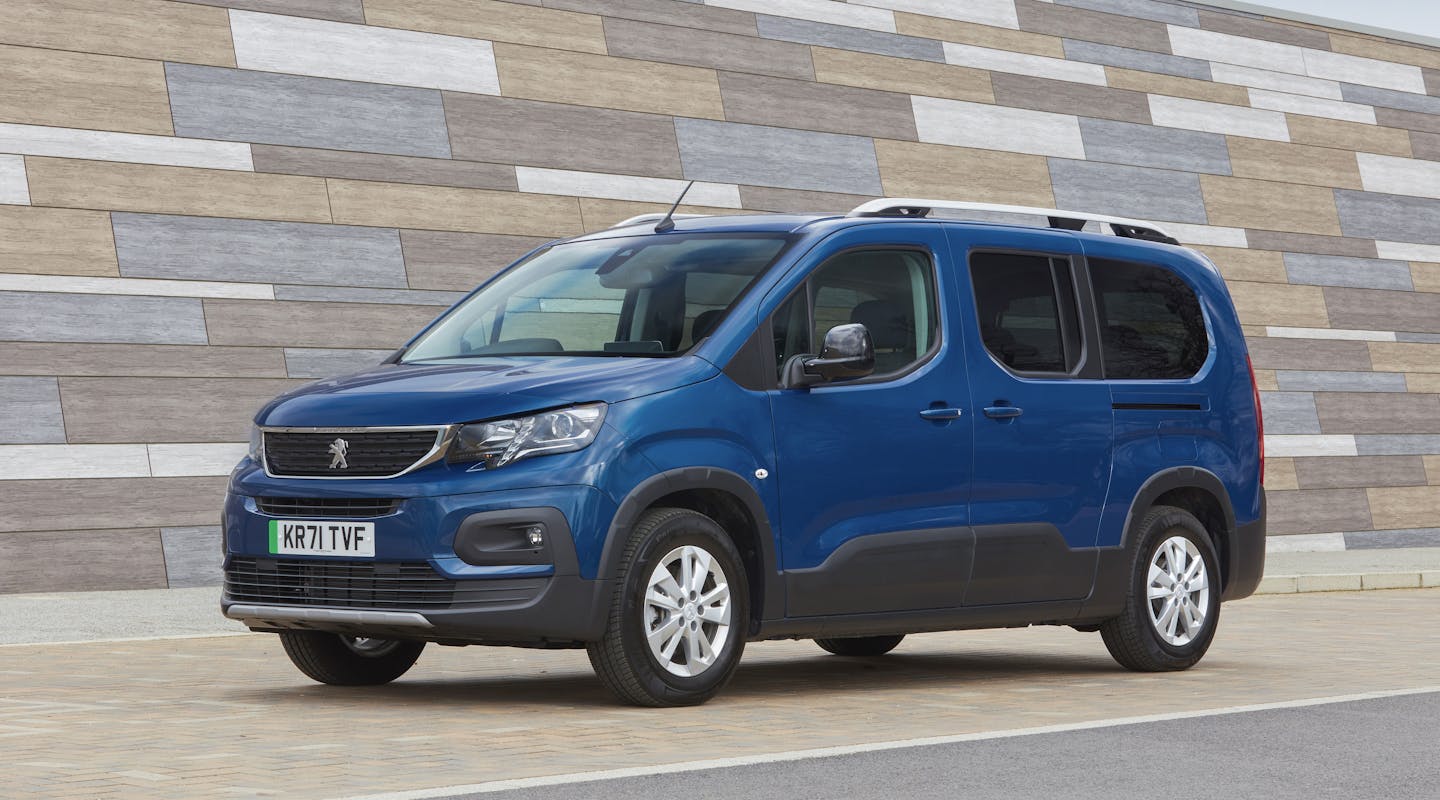 Ein Peugeot e-Rifter parkt vor einer Mauer