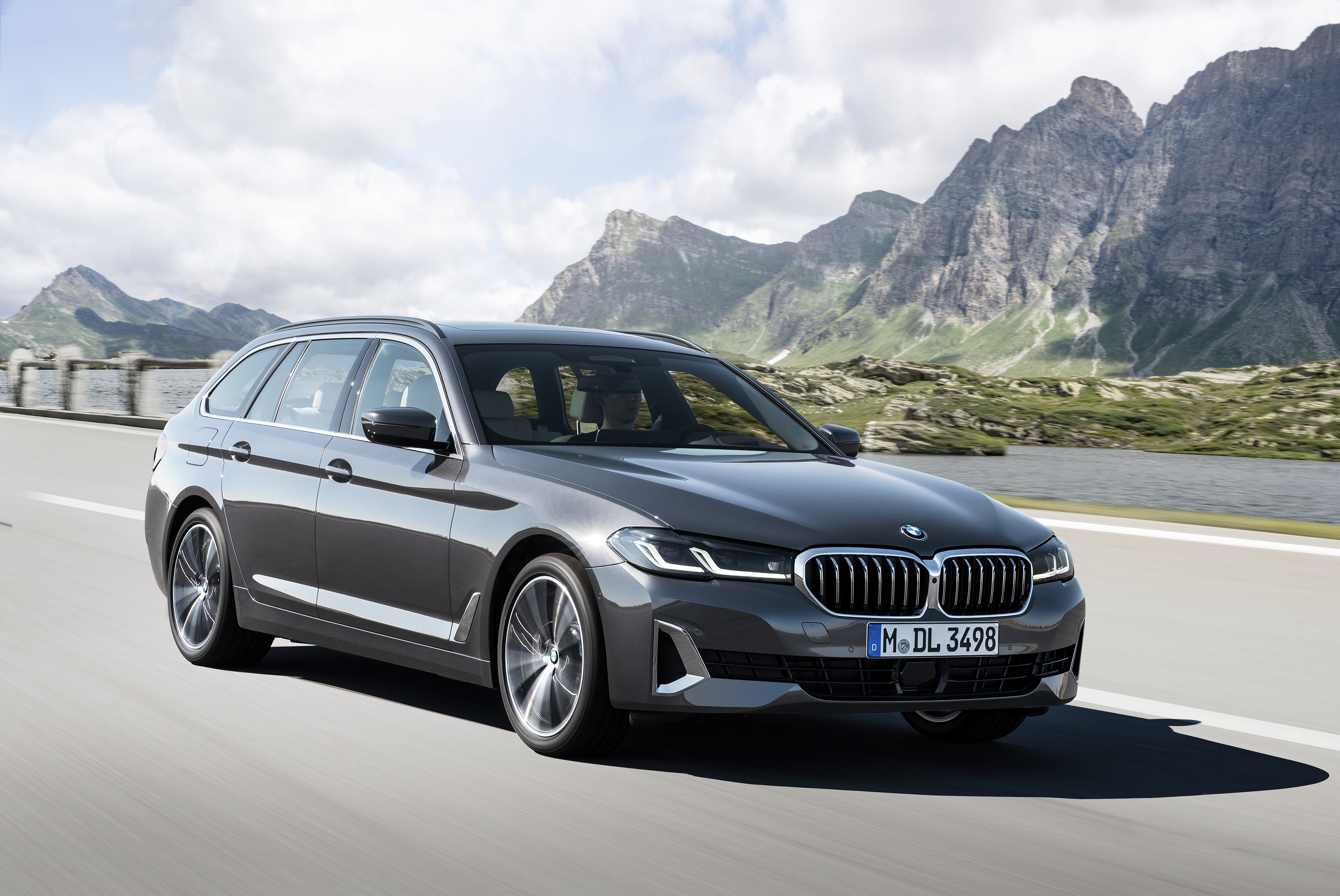 BMW 530d Touring G31 in Grau, dynamische Frontansicht vor Bergpanorama