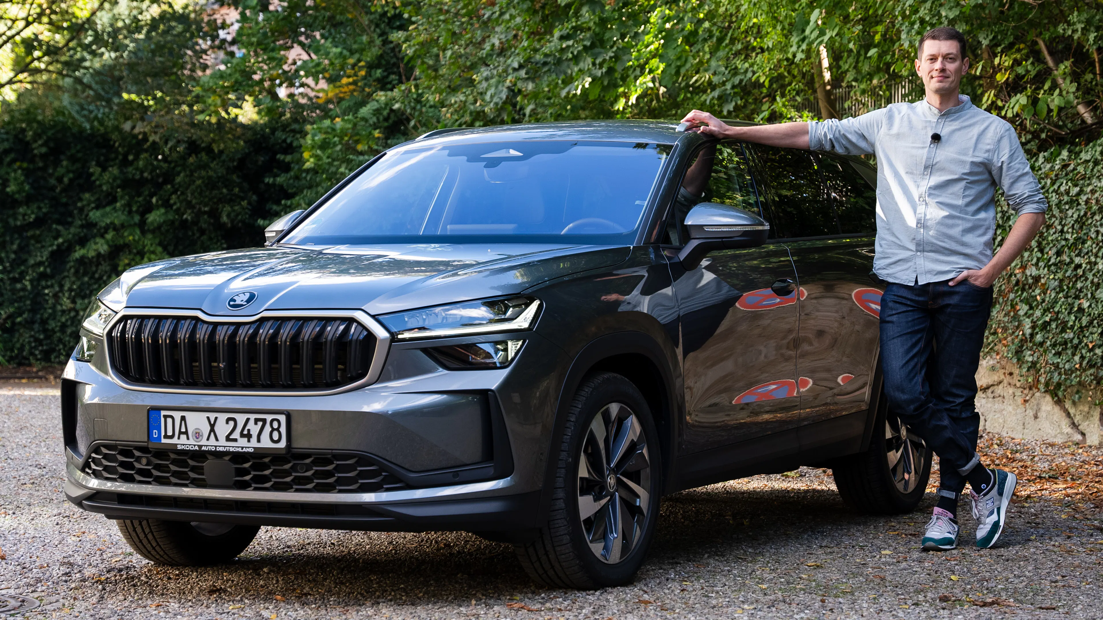 Ein grausilberner Škoda Kodiaq auf einem Parkplatz mit dem Redakteur, am Auto stehend