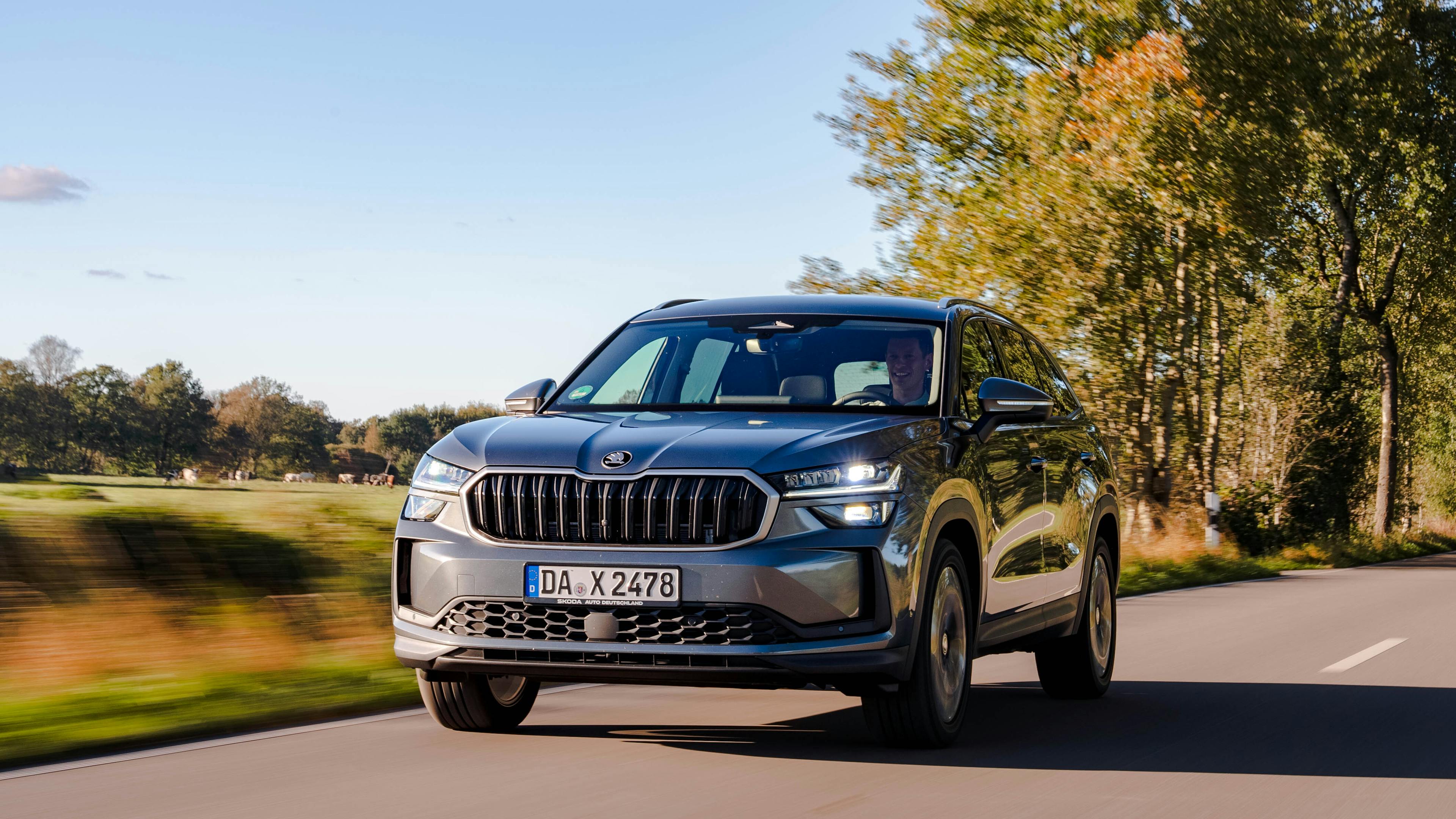 Gray Škoda Kodiaq, driving on an autumnal country road.