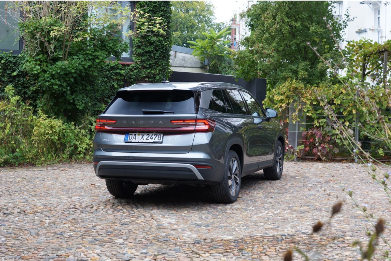  The rear view of a gray Škoda Kodiaq standing in a cobblestone parking lot.