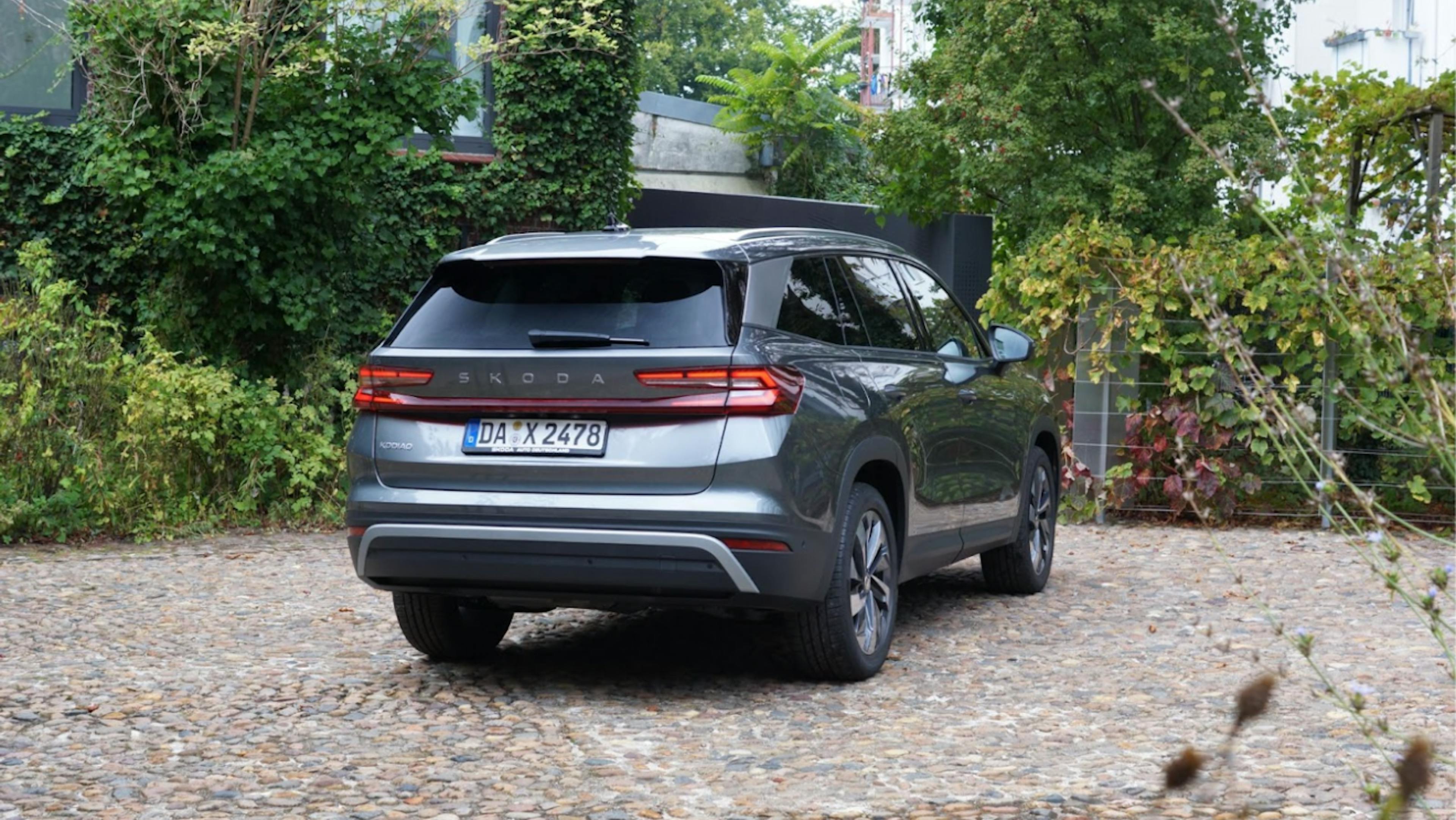 The rear view of a gray Škoda Kodiaq standing in a cobblestone parking lot.