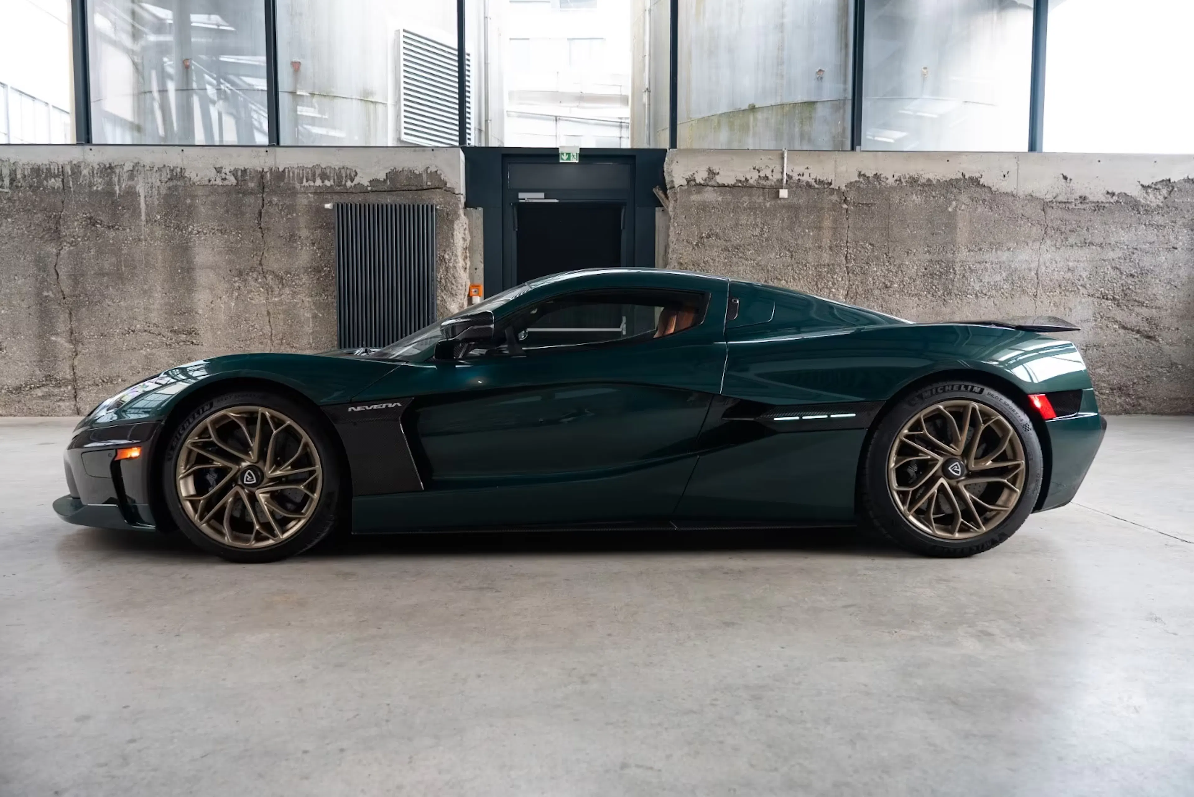 Ein dunkel lackierter Rimac Nevera in einer Halle.