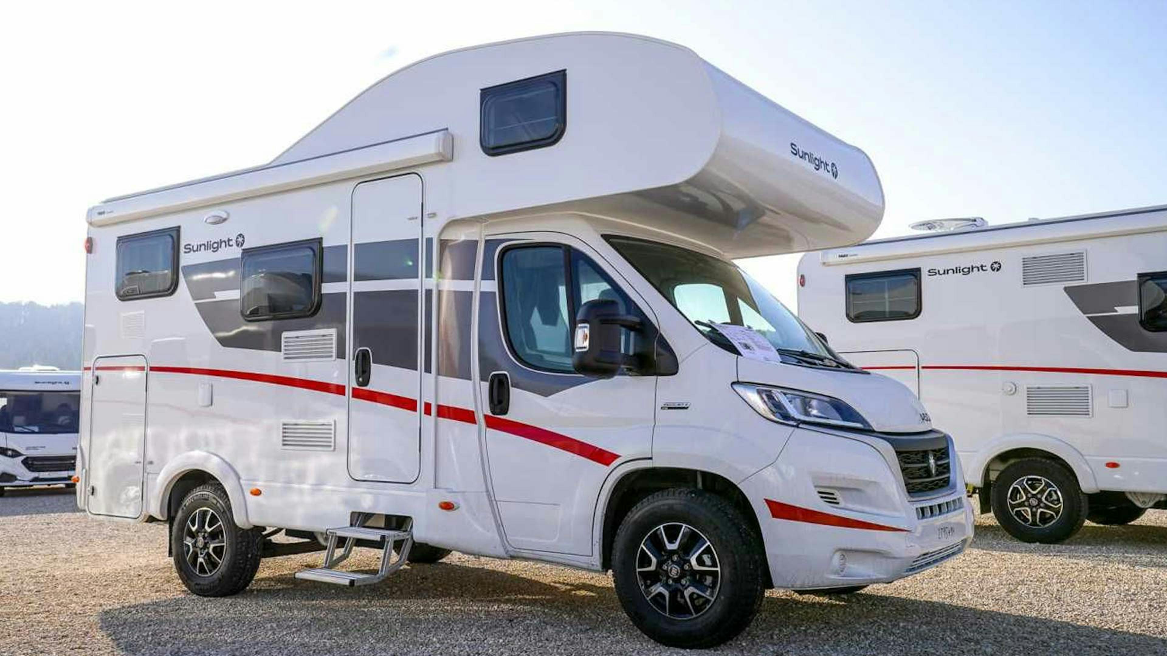 Ein Sunlight A 60-Wohnmobil mit Alkoven steht auf einem Campingplatz.
