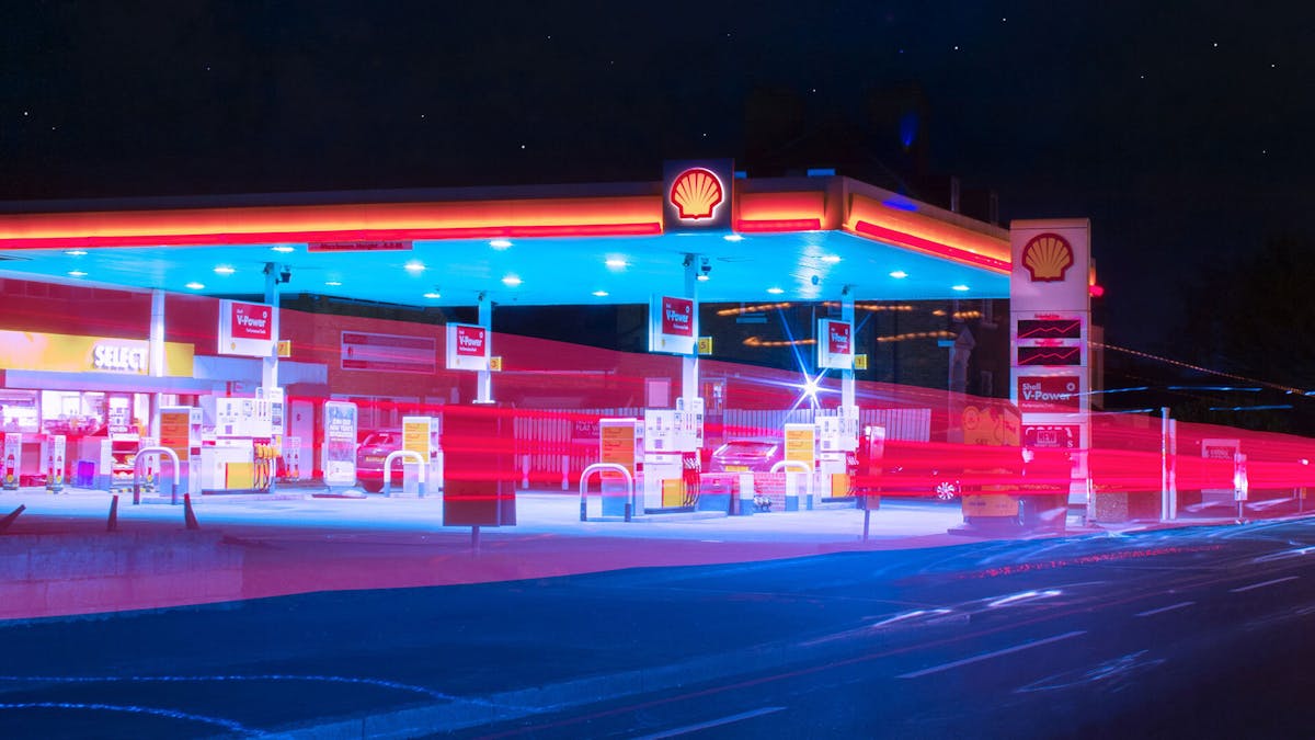 Blick auf eine beleuchtete Shell-Tankstelle bei Nacht