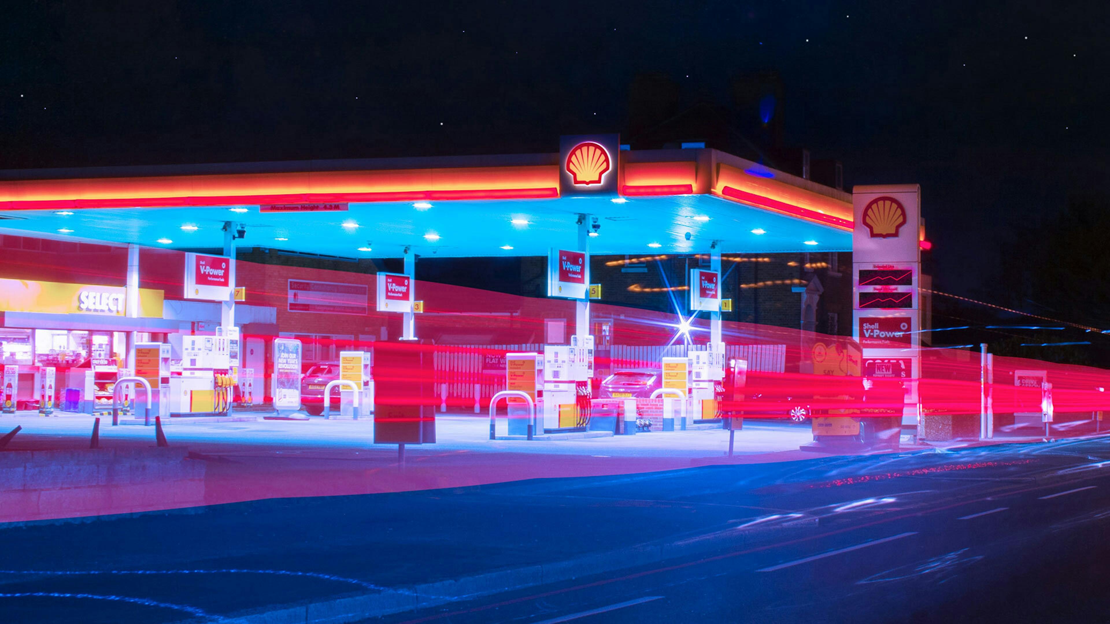 Blick auf eine beleuchtete Shell-Tankstelle bei Nacht 