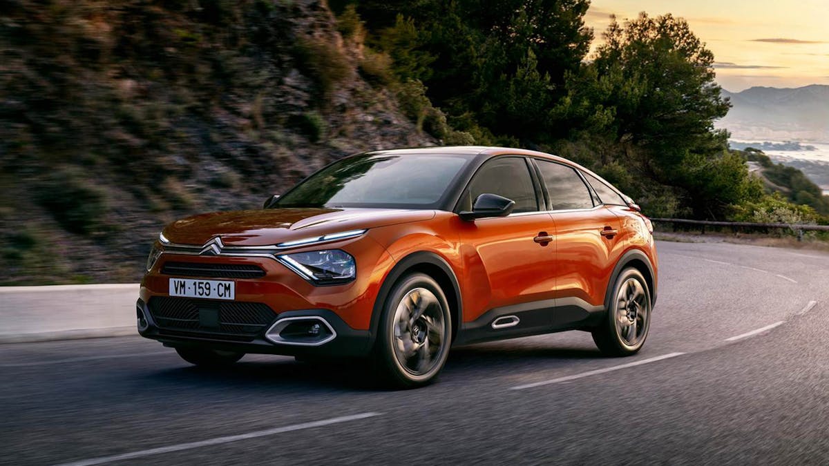 Ein roter Citroën C4 fährt eine kurvige Küstenstraße entlang.