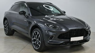 Ein schwarzer Aston Martin steht in einem Raum mit weißen Wänden