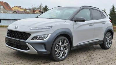 Ein grauer Hyundai Kona Select Hybrid steht auf einem Parkplatz.