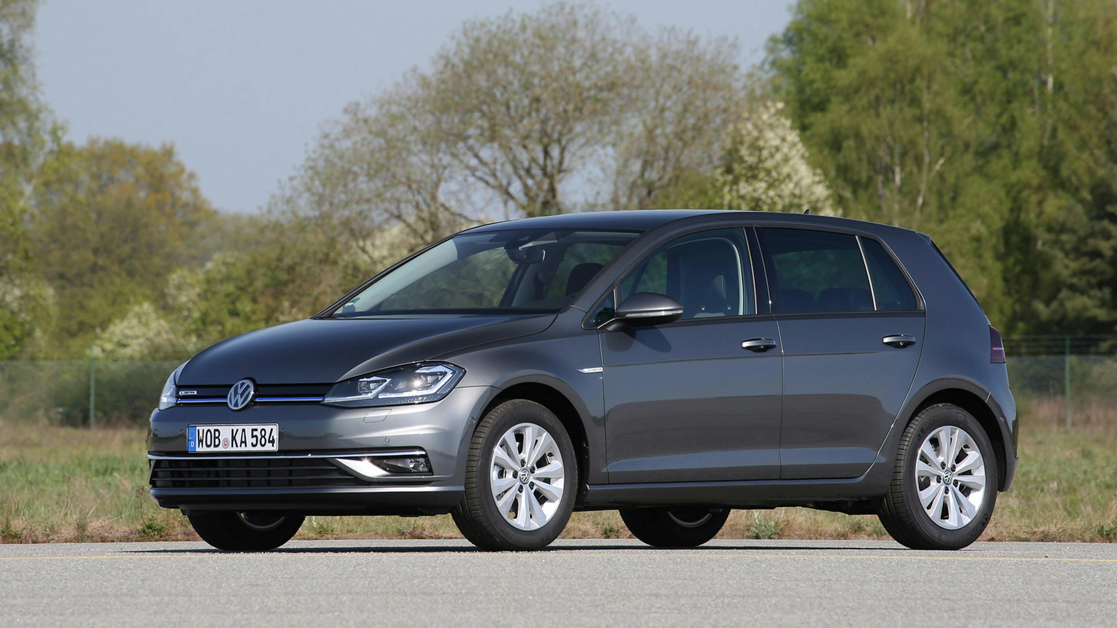 Ein schwarzer VW Golf TGI mit CNG-Antrieb steht auf einem Parkplatz mit Bäumen im Hintergrund.