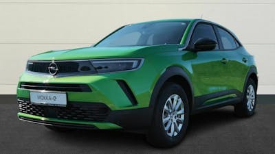 Ein grüner Opel Mokka-e steht vor einer hellen Wand.