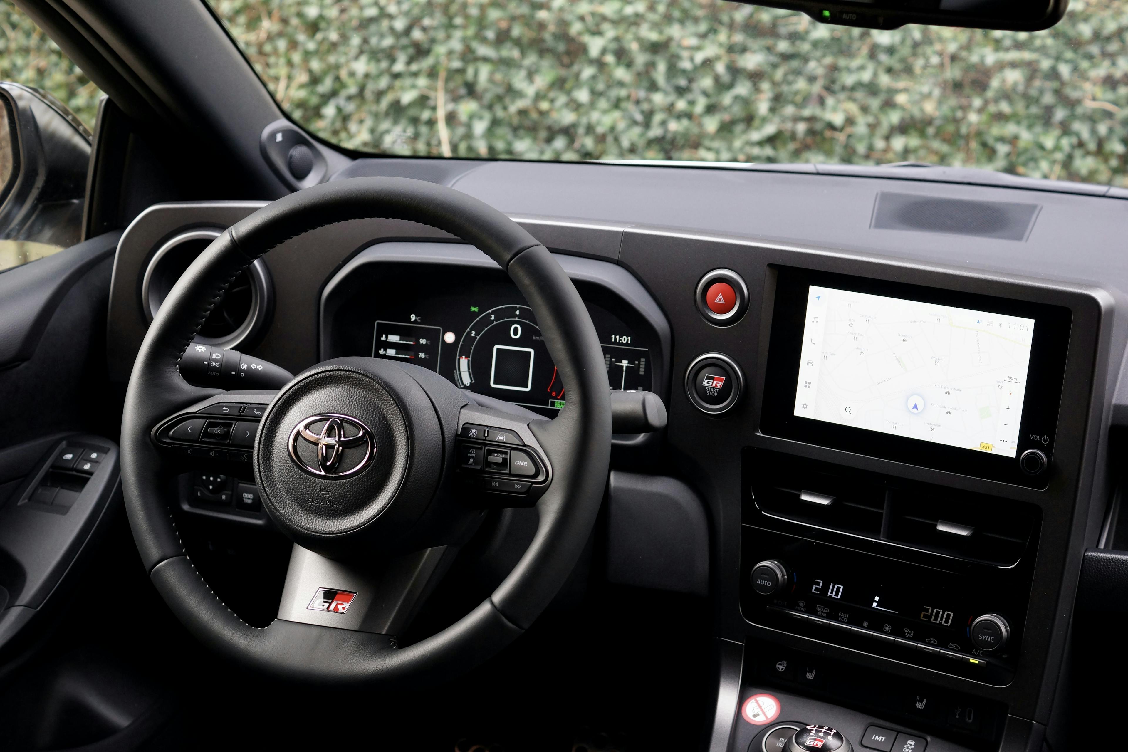 Das Cockpit eines Toyota GR Yaris Facelift mit Lenkrad und Monitor.