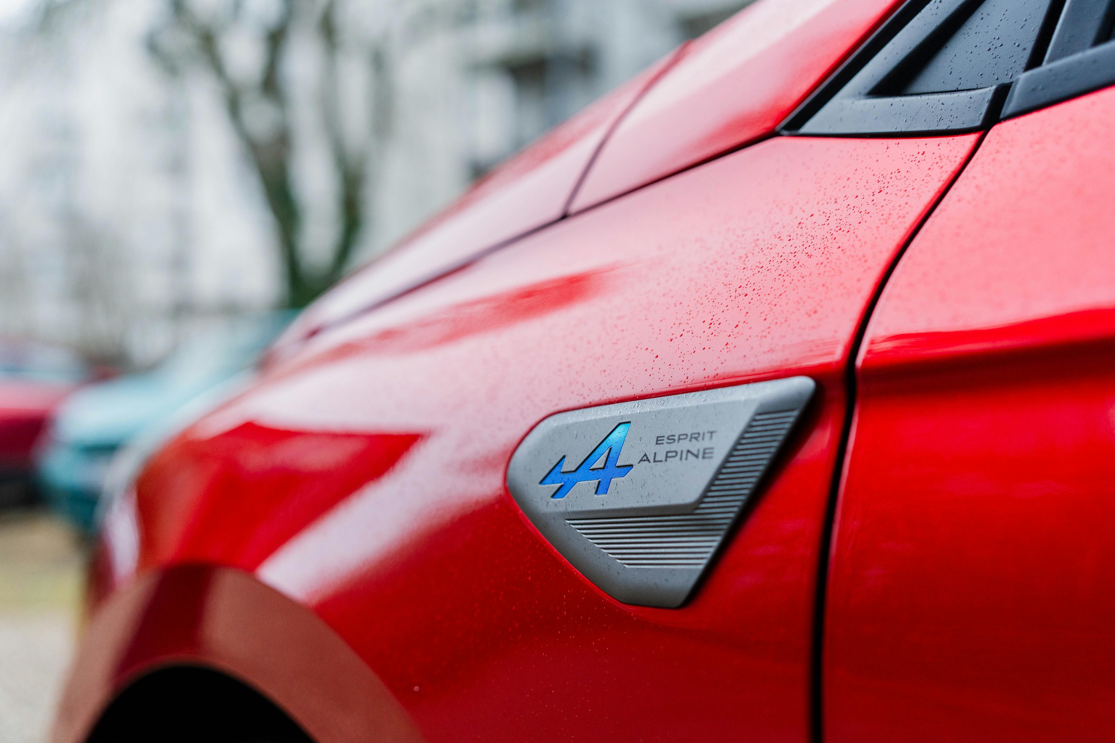 Detailaufnahme der Esprit Alpine Plakette auf einem roten Renault Clio.