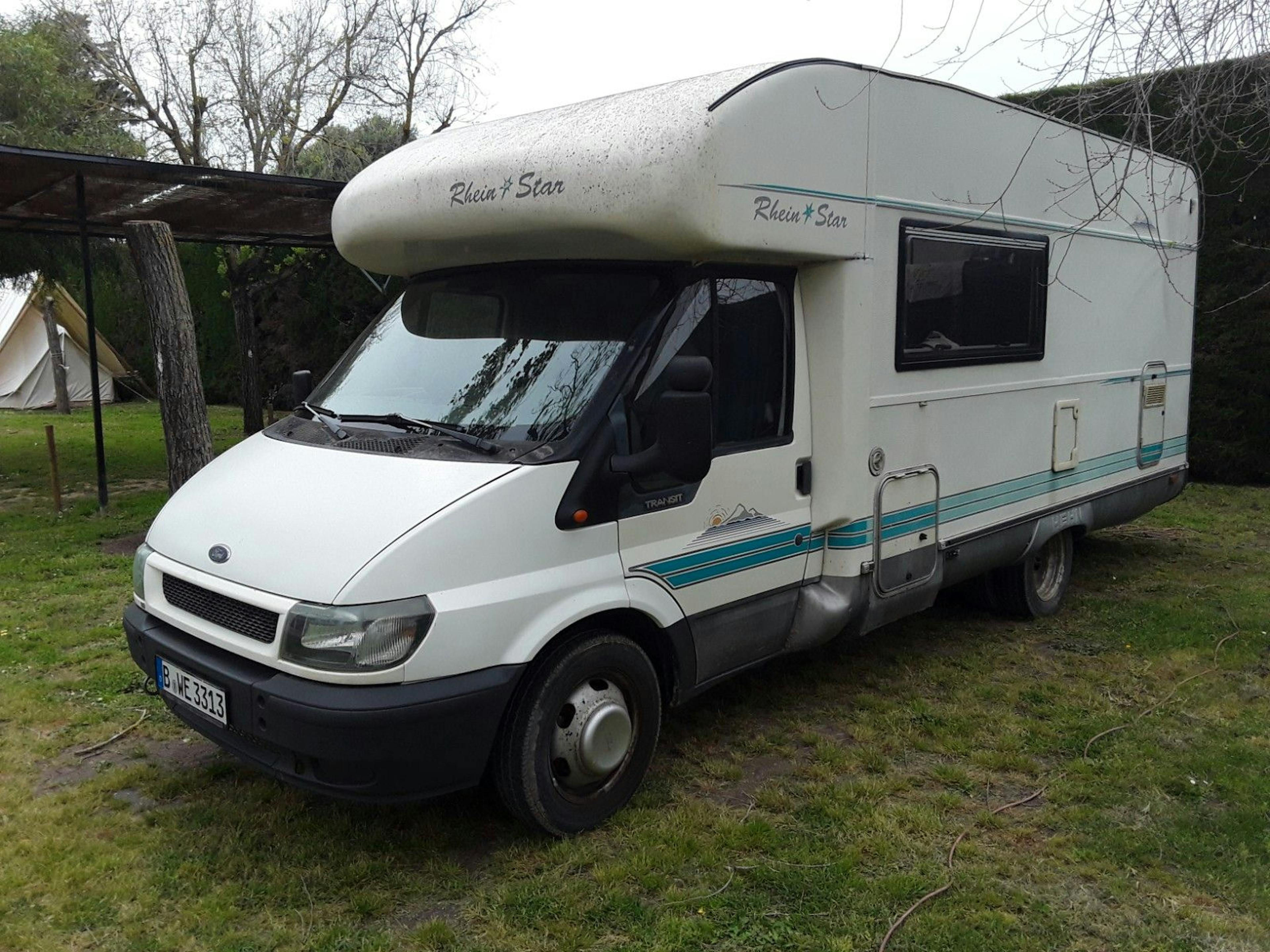 Ein weißes Wohnmobil steht auf einem Rasen.