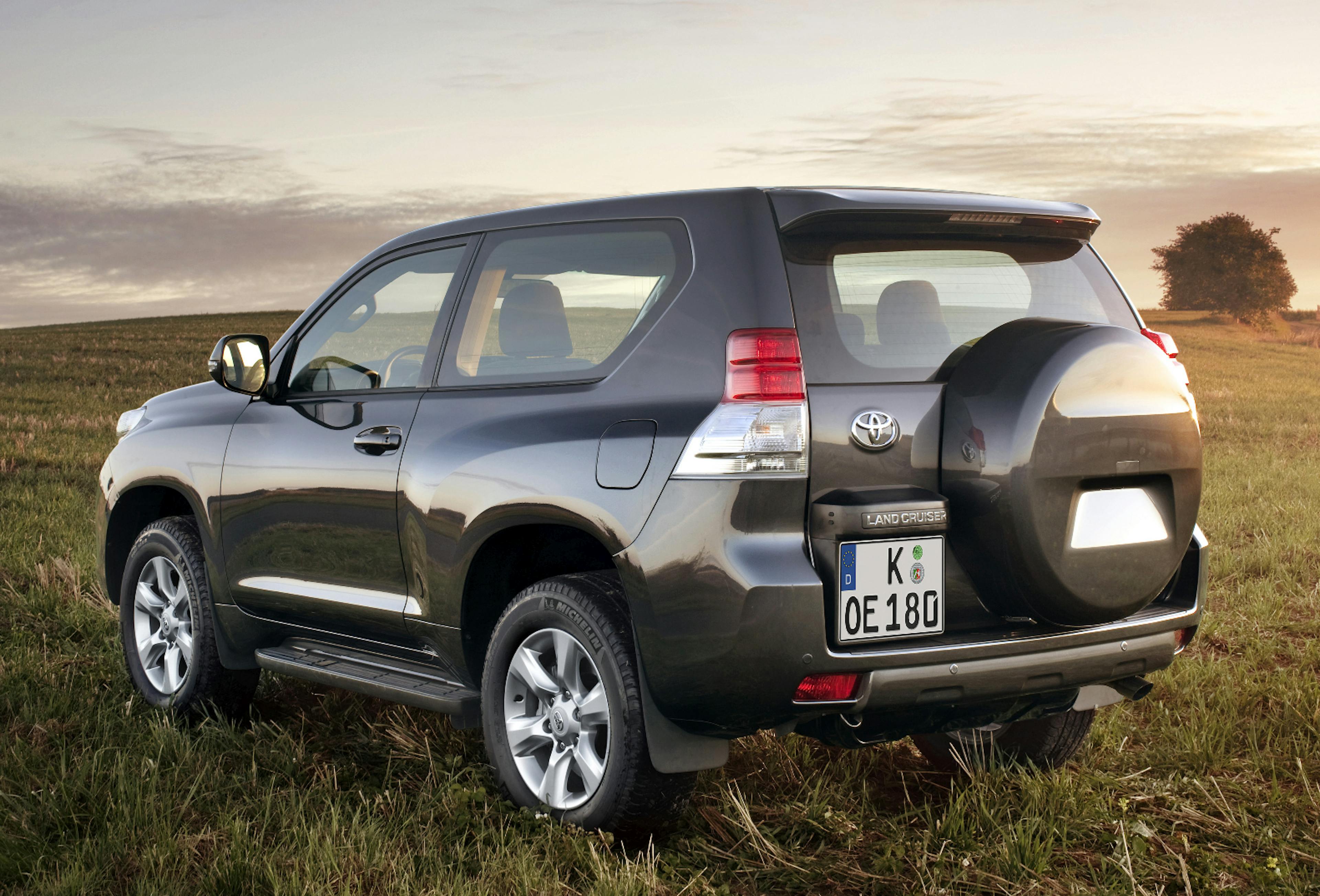 Ein schwarzer Toyota Land Cruiser steht auf einer Wiese.