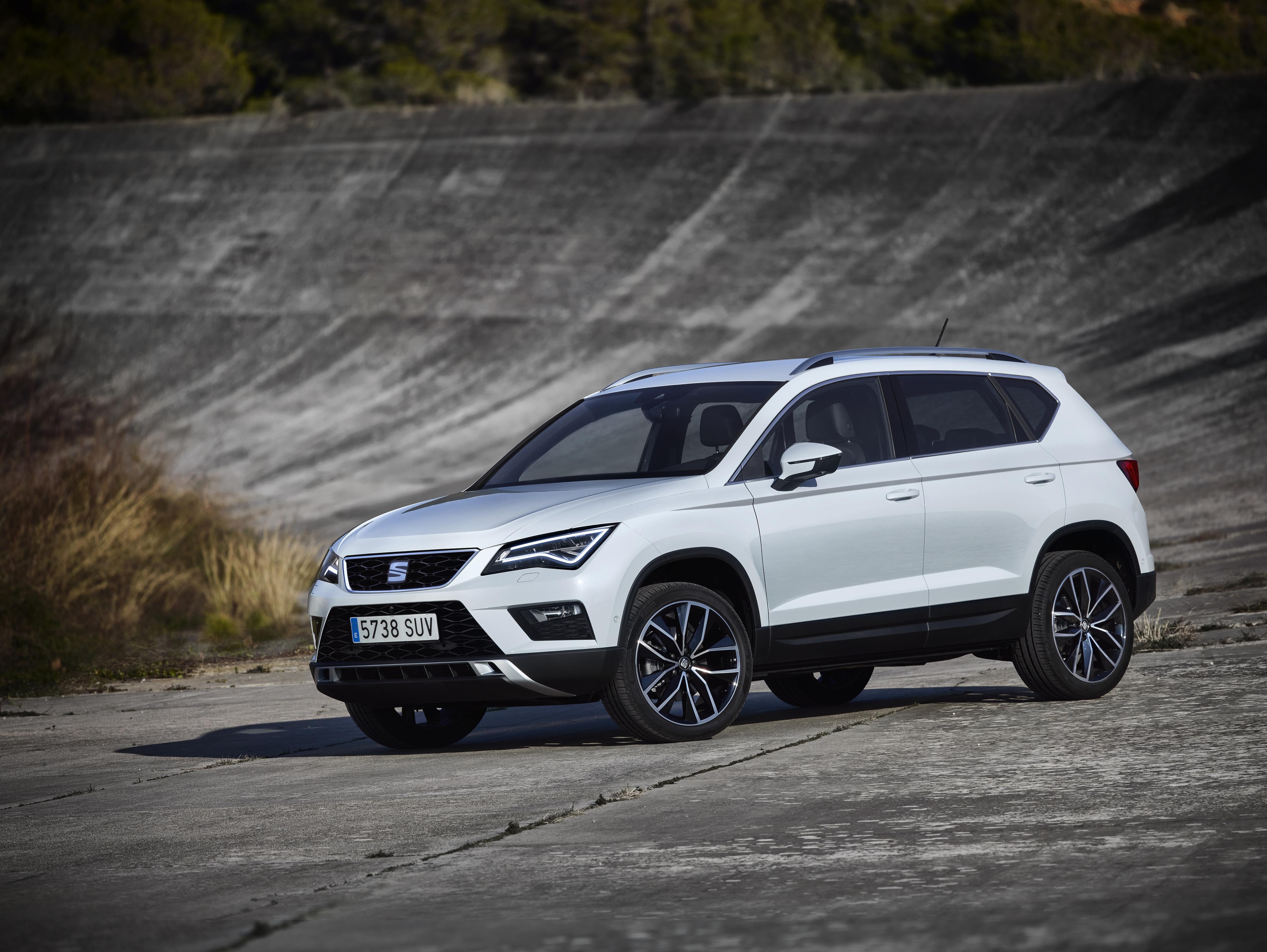 Ein weißer Seat Ateca parkt vor einer Steilkurve einer alten Rennstrecke.