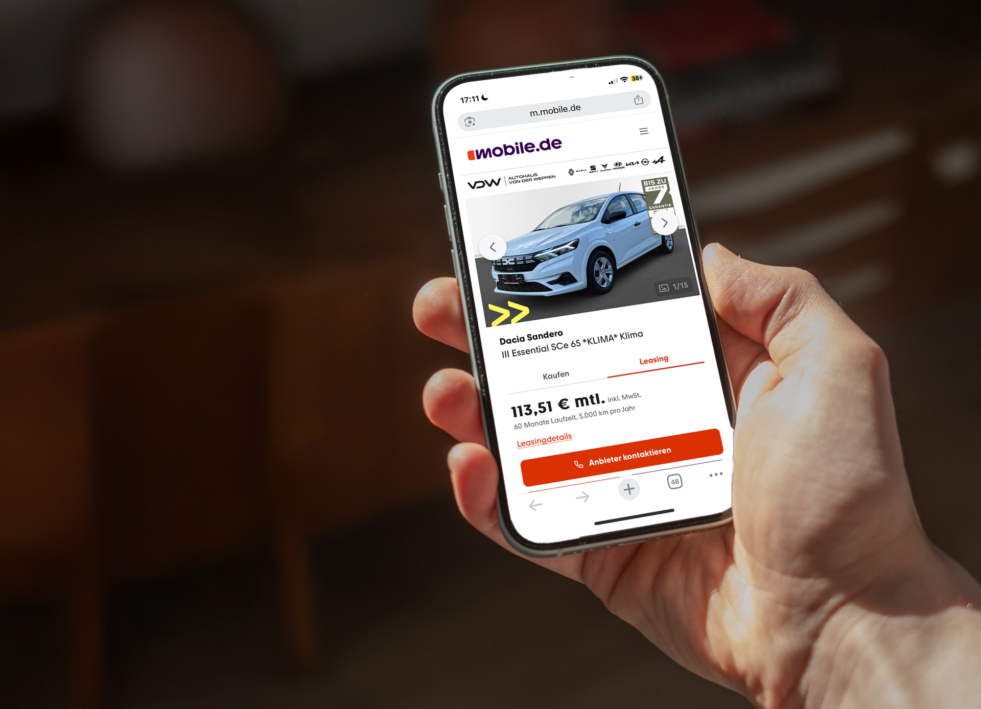 Mann hält Smartphone in der Hand. Mit Leasing Angebot auf dem Bildschirm