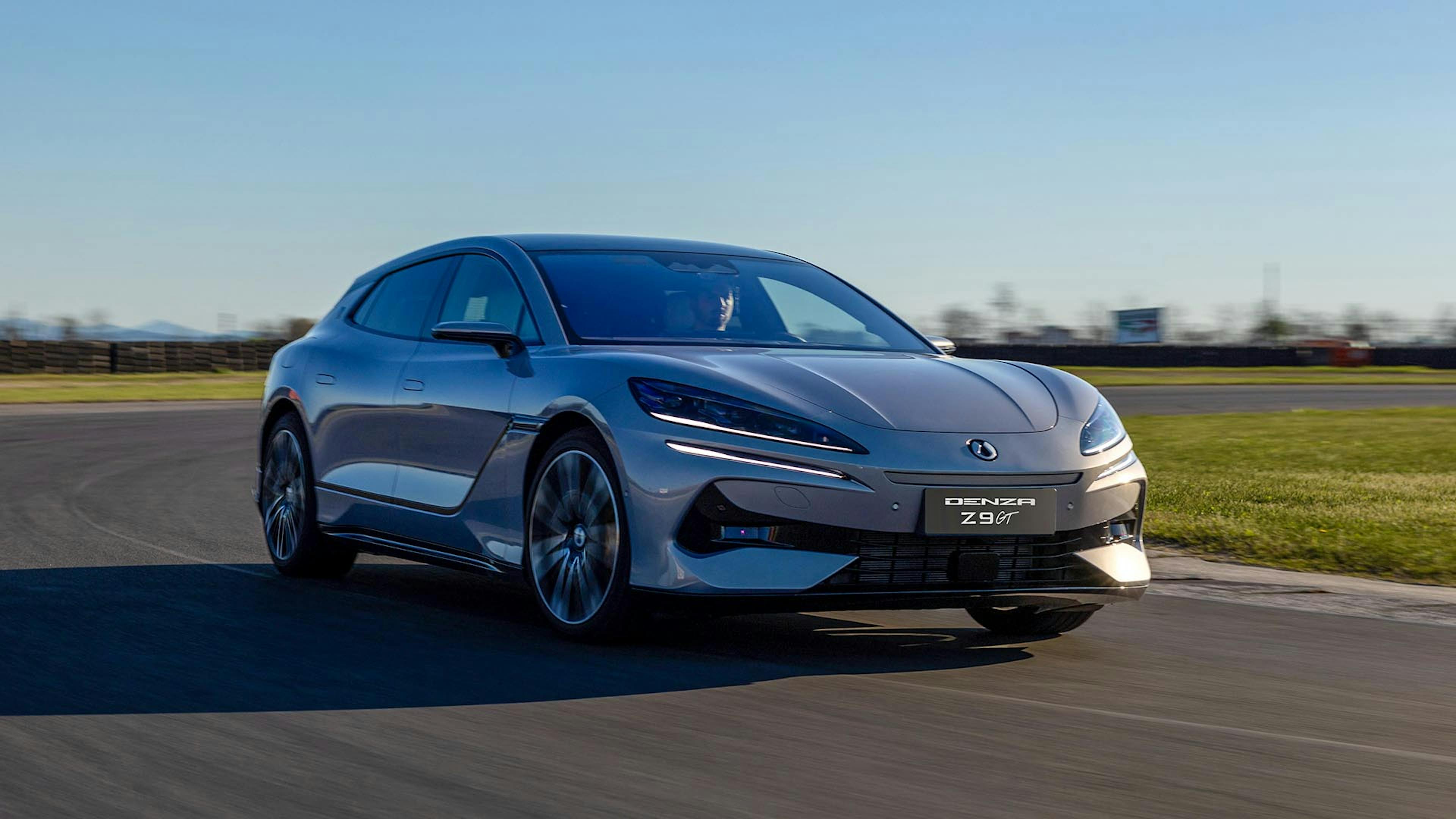 Ein grauer Denza Z9 GT fährt auf einer Rennstrecke um eine Kurve.