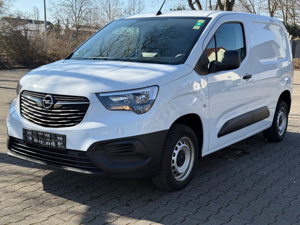 Ein weißer Opel Combo Cargo parkt auf einem Hof.
