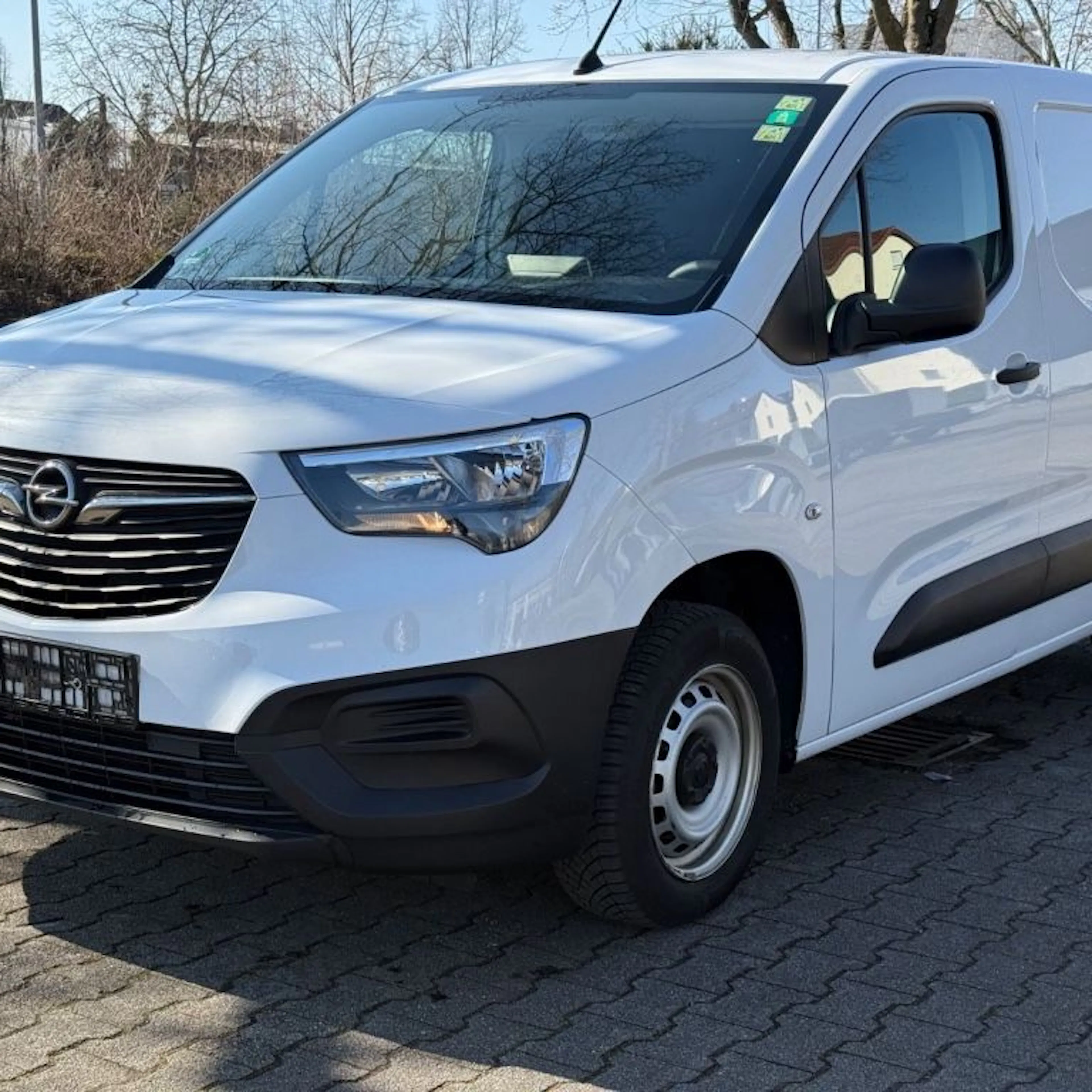 Ein weißer Opel Combo Cargo parkt auf einem Hof.