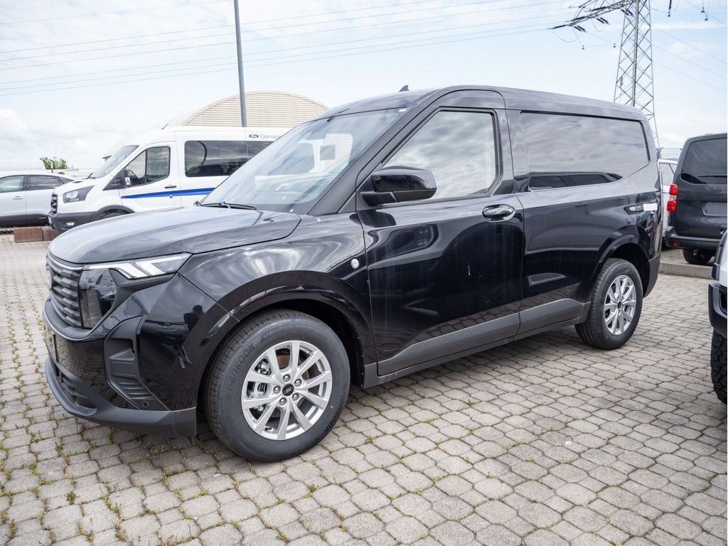 Ein schwarzer Ford Transit Courier parkt auf einem Hof.