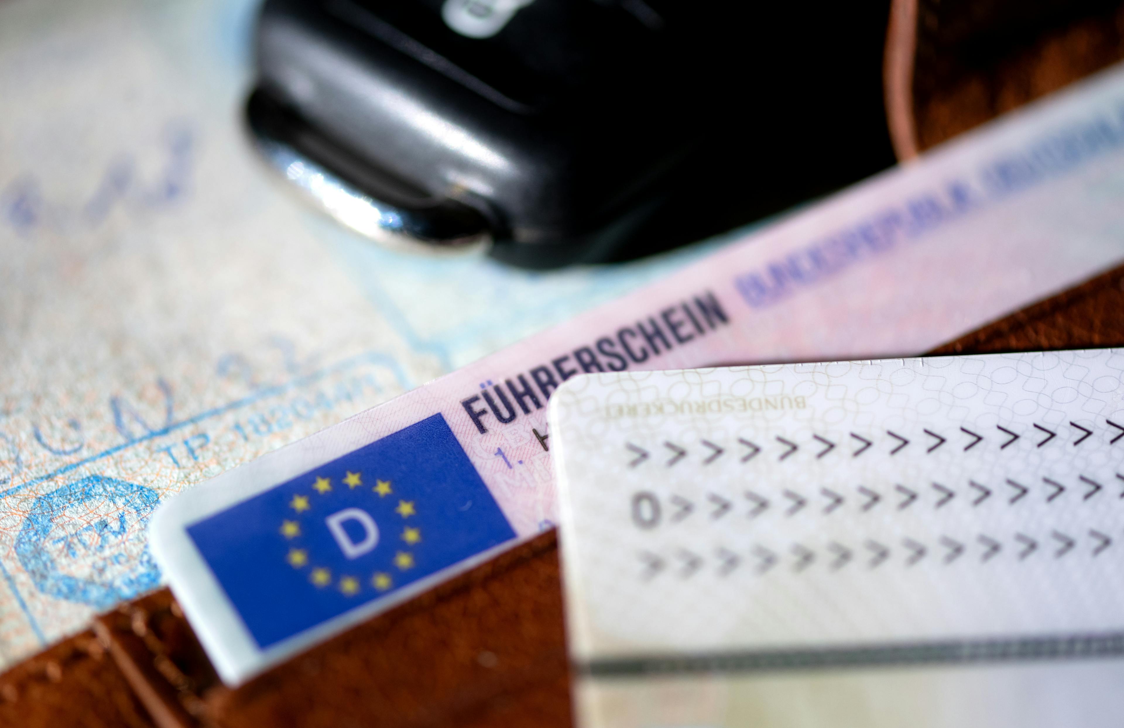 Mehrere Dokumente liegen auf einer Oberfläche, im Vordergrund ein deutscher Führerschein im neuen EU-Kartenformat, erkennbar am blauen EU-Feld mit dem „D“-Länderkürzel und Sternenkranz.